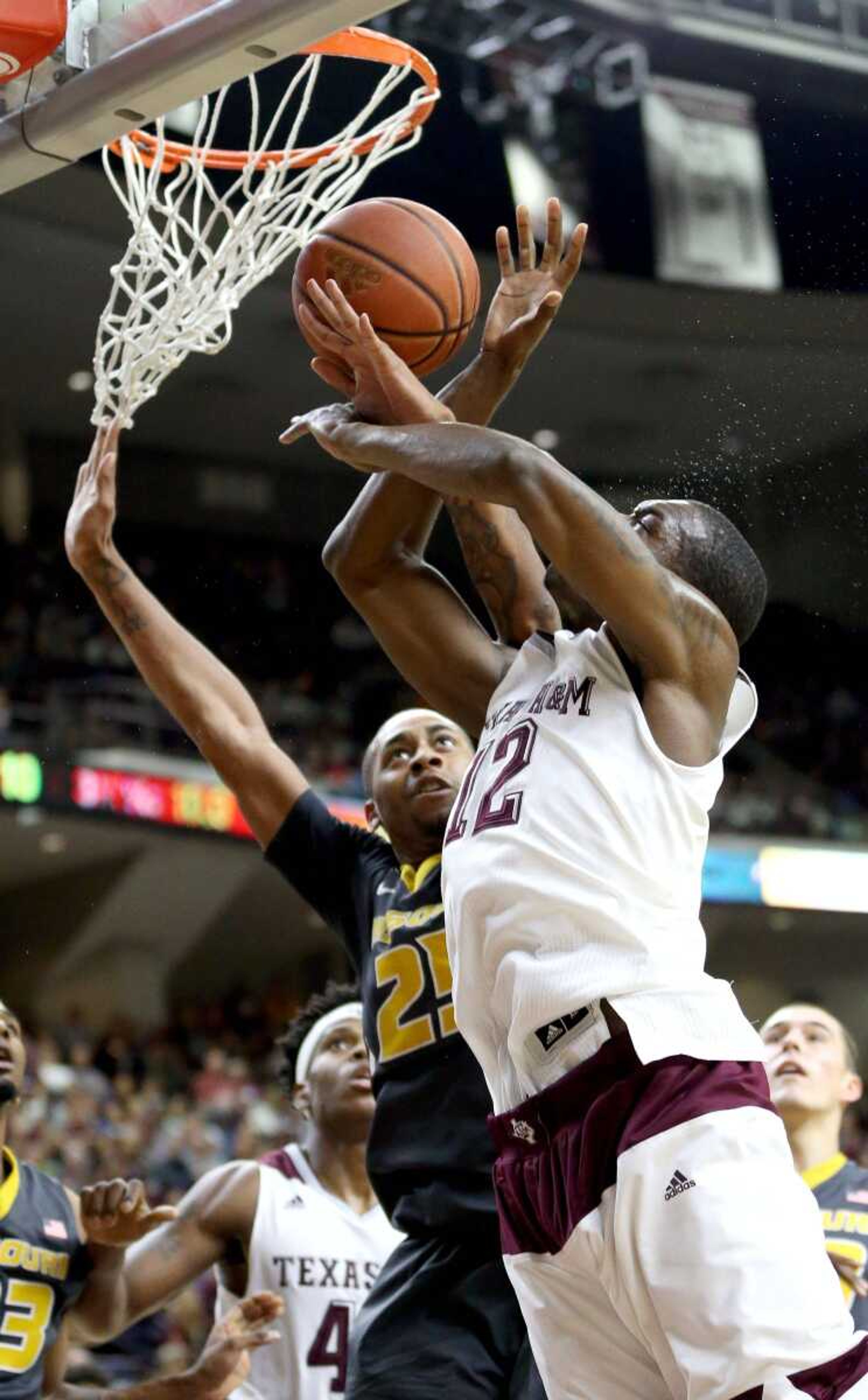 Texas A&M's Jalen Jones is fouled by Missouri's Russell Woods while shooting during the first half Saturday in College Station, Texas.