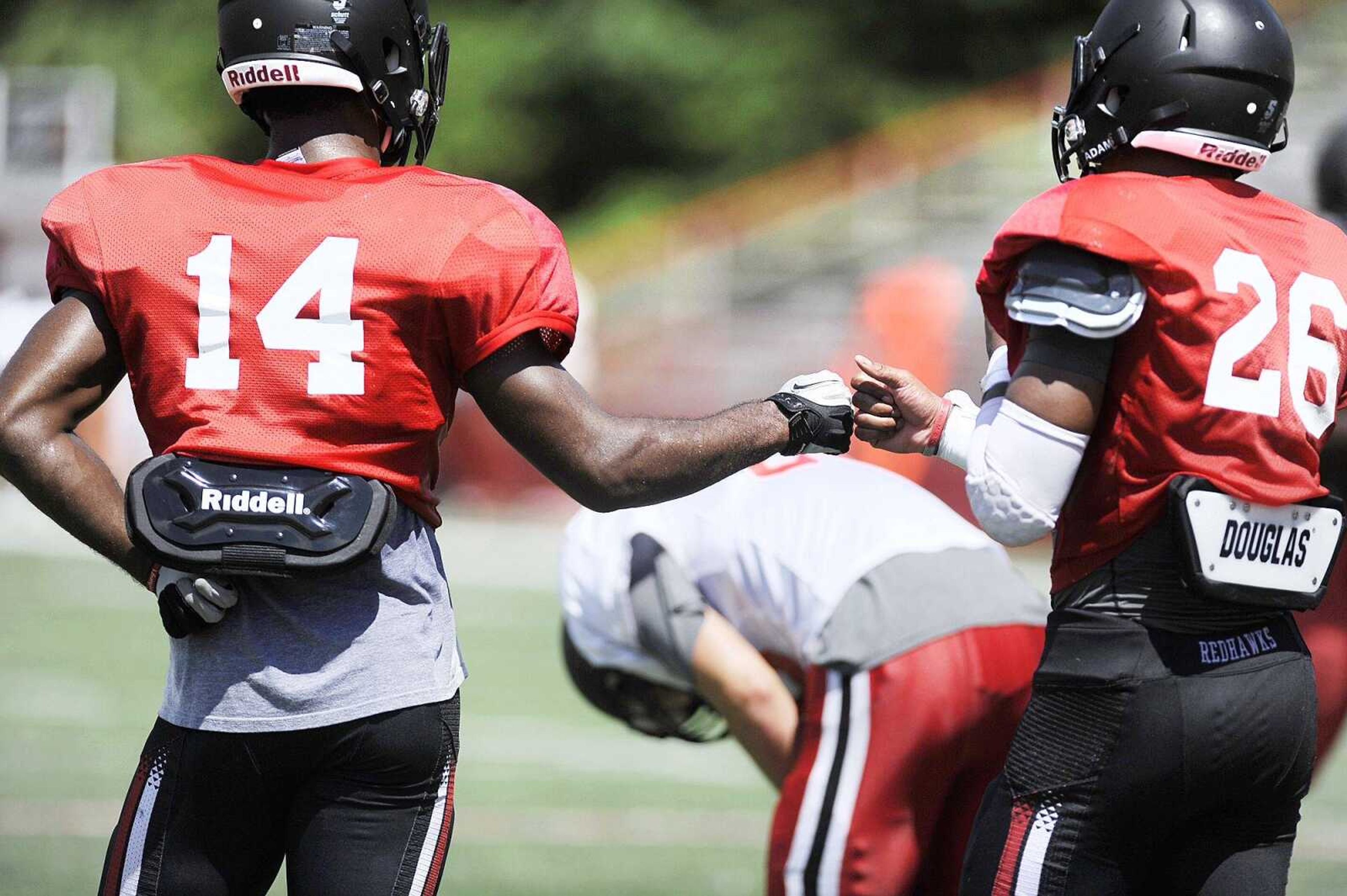 Southeast Missouri State senior safety David Coley (14) and junior strong safety Taron Divens congratulate during practice Tuesday at Houck Stadium. (Laura Simon)