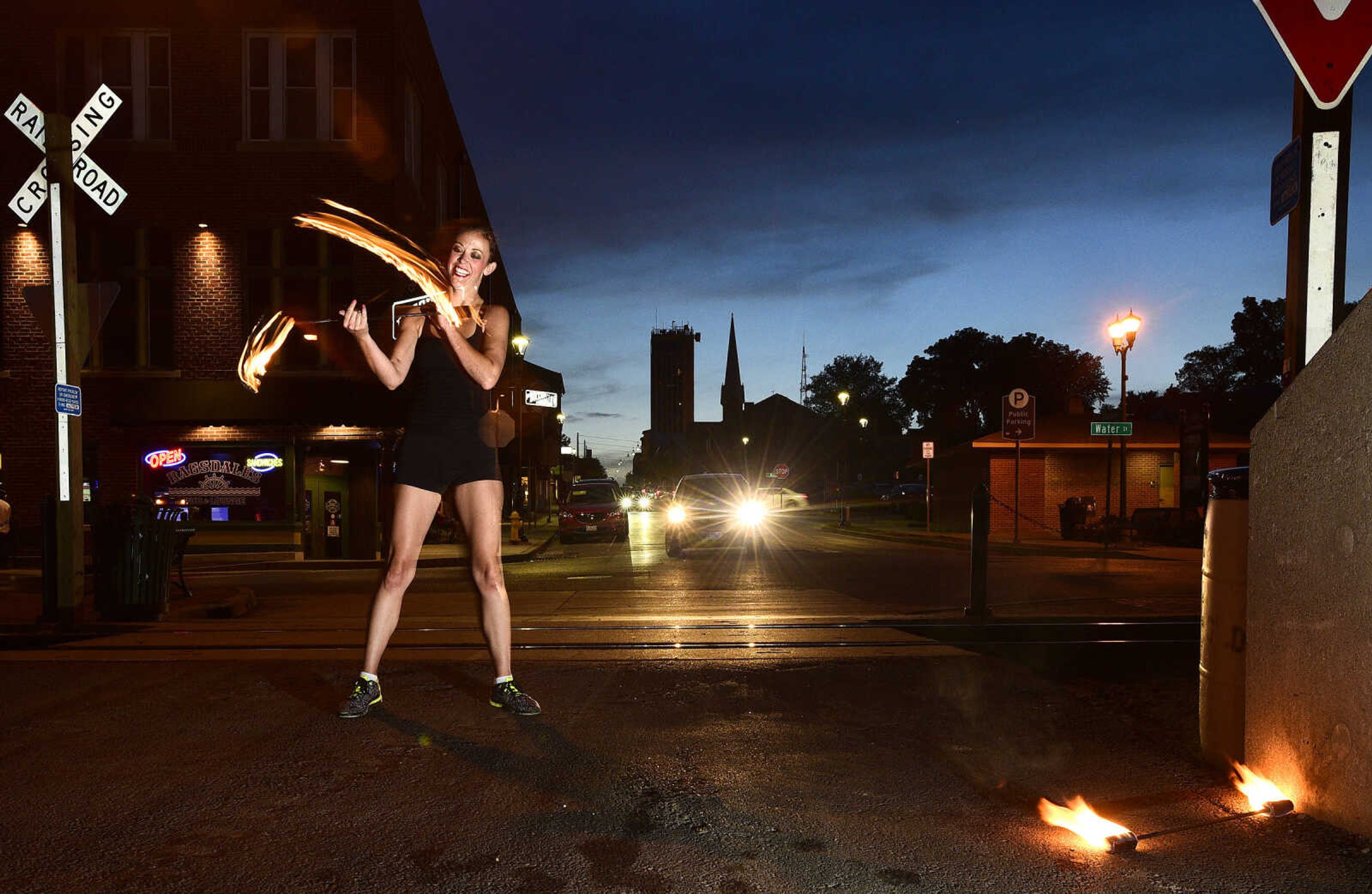 Erin Fluegge twirls flaming batons along the riverfront on Friday, June 16, 2017, in downtown Cape Girardeau.