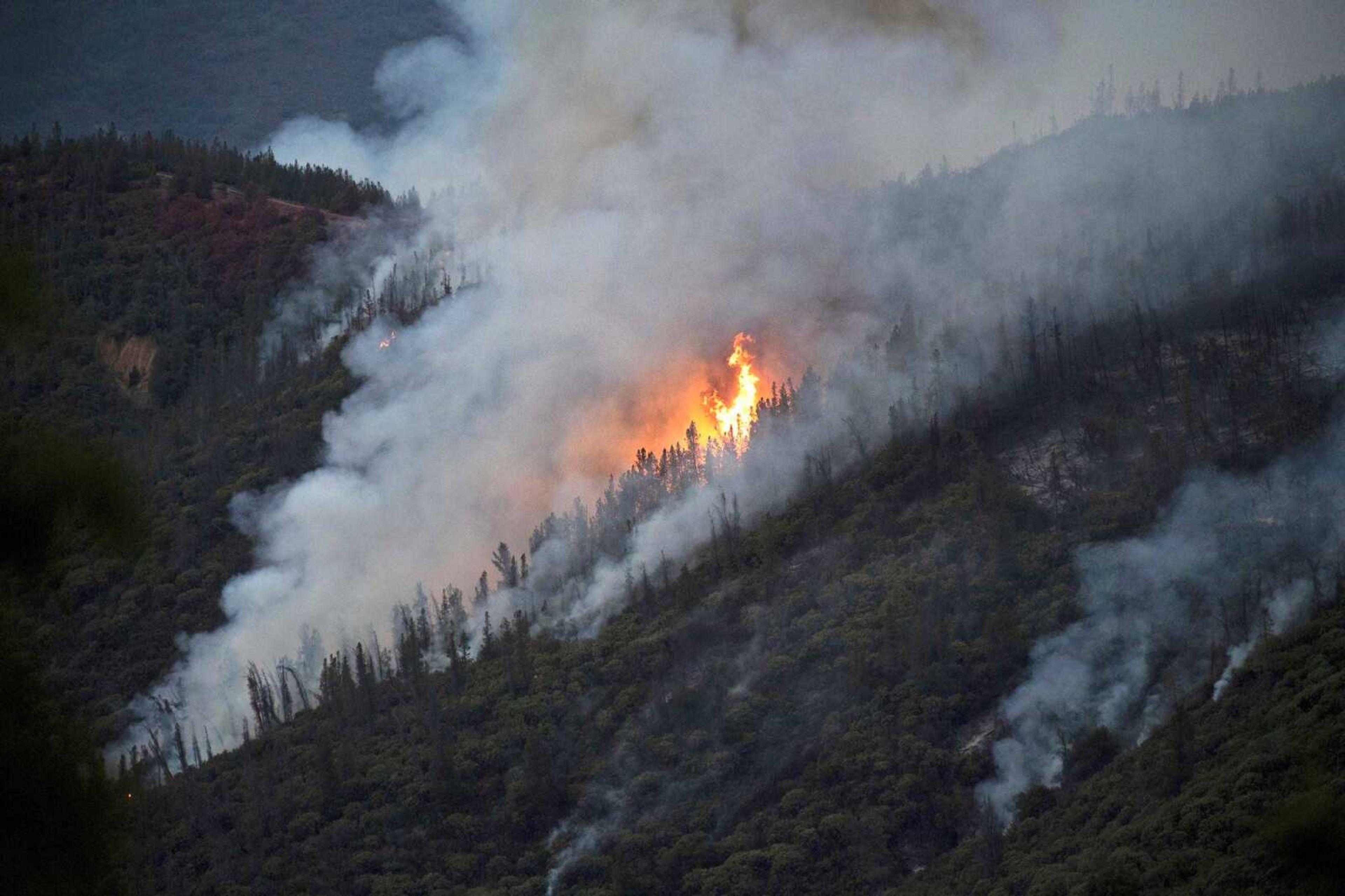 Flames from a wildfire burn down a hillside July 15 in unincorporated Mariposa County, California, near Yosemite National Park. California authorities will shut down Yosemite Valley for several days beginning today as crews try to stop a stubborn and growing wildfire from spreading into Yosemite National Park.