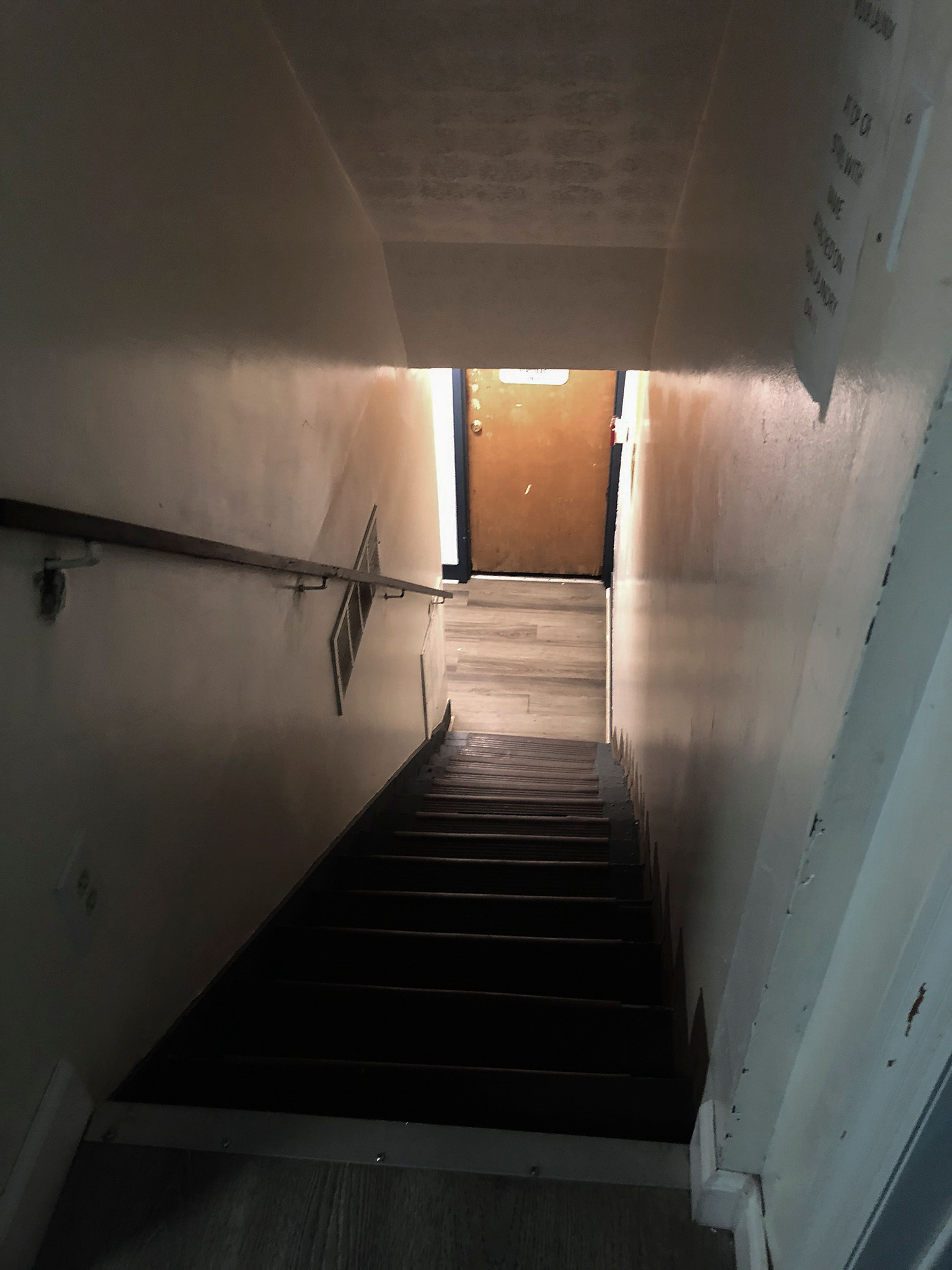 This June 13, 2024 photo shows a darkened stairway leading down to the basement of the Huntington Addiction Wellness Center, which was formerly the Huntington Work Release Center, where April Youst was assigned as a prisoner in Huntington W. Va. (AP Photo/Margie Mason)