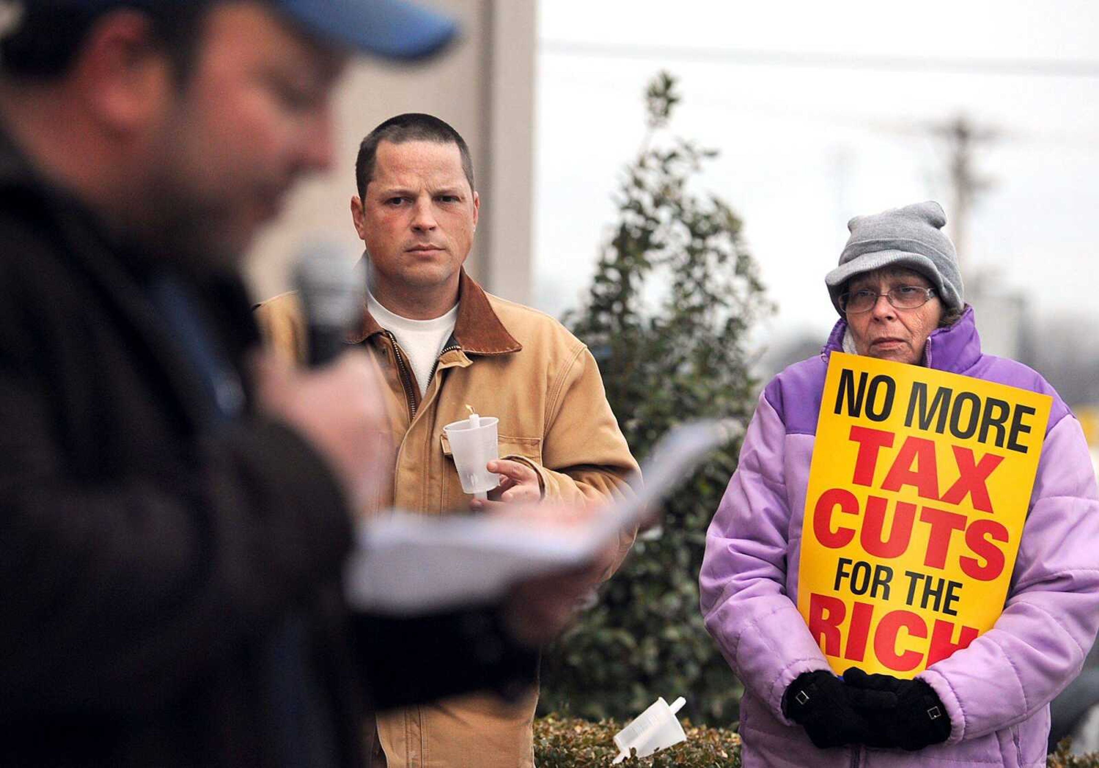 Susan Hester, right, and John Long listen to Jebediah Morris outside Rep. Jo Ann Emerson&#8217;s Cape Girardeau office Monday evening during a national candlelight campaign against cuts. About 15 people gathered for the event to keep pressure on Congress to end tax cuts to the richest 2 percent, and to refuse any cuts to Social Security, Medicaid and Medicare. (Laura Simon)