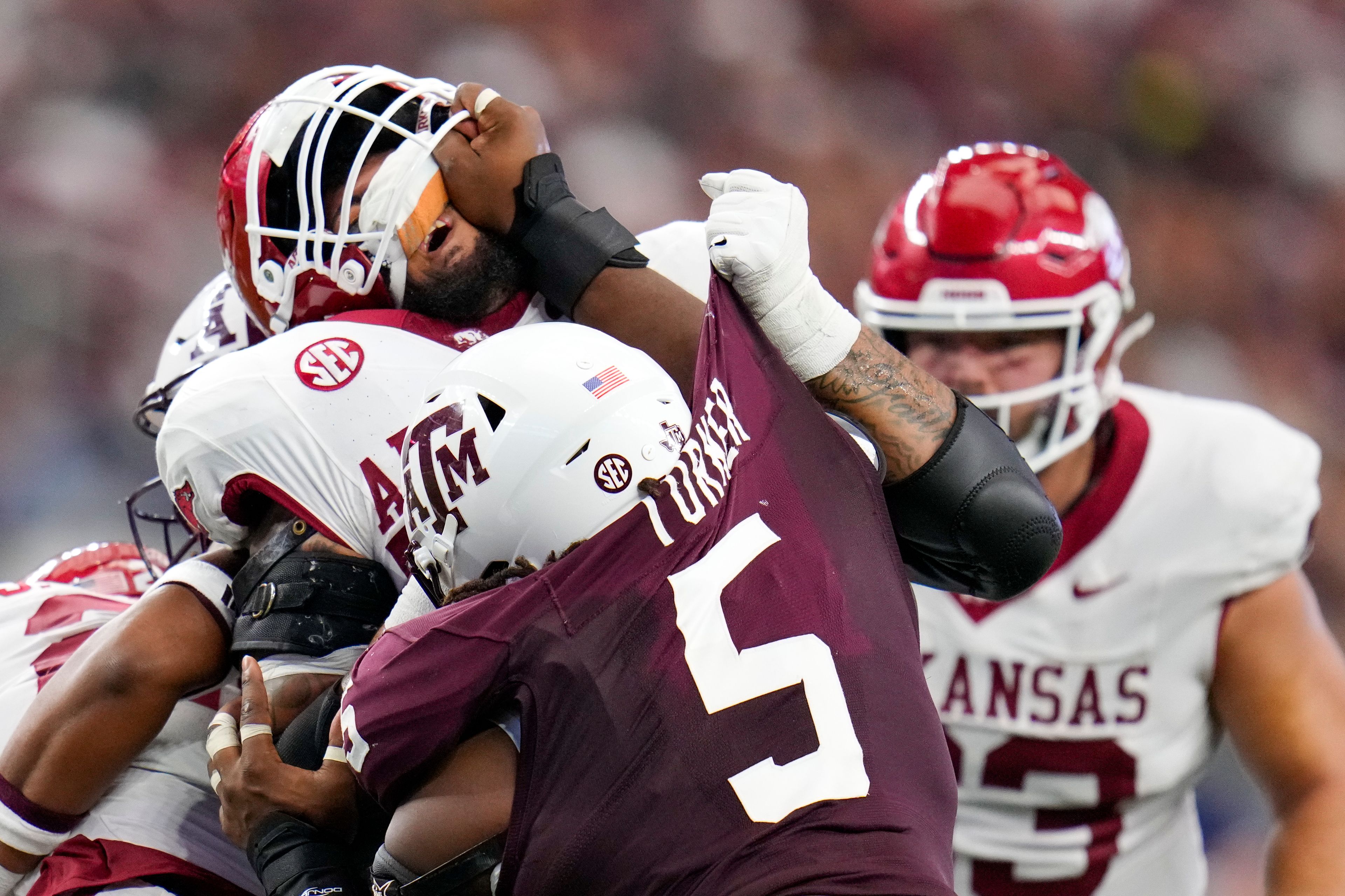 Texas A&M defensive lineman Shemar Turner's hand is seen on the face of Arkansas offensive lineman Keyshawn Blackstock while rushing in during the first half of an NCAA college football game, Saturday, Sept. 28, 2024, in Arlington, Texas. (AP Photo/Julio Cortez)