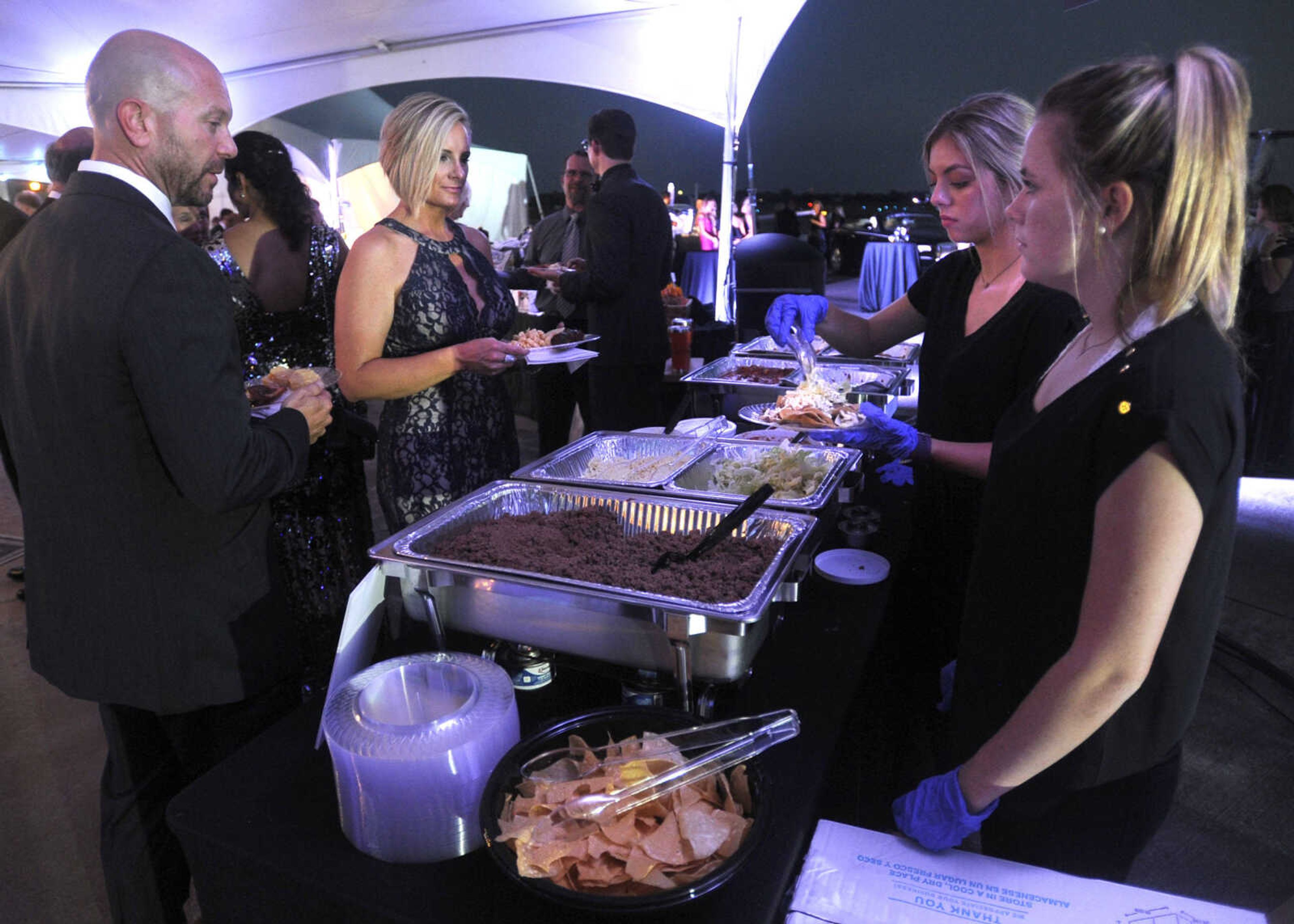 FRED LYNCH ~ flynch@semissourian.com
Jason and Nacole Lukefahr are served food by Emma Biermann, right, and Bree Bangert Saturday, Sept. 23, 2017 at the American Cancer Society Gala at the Cape Girardeau Regional Airport.