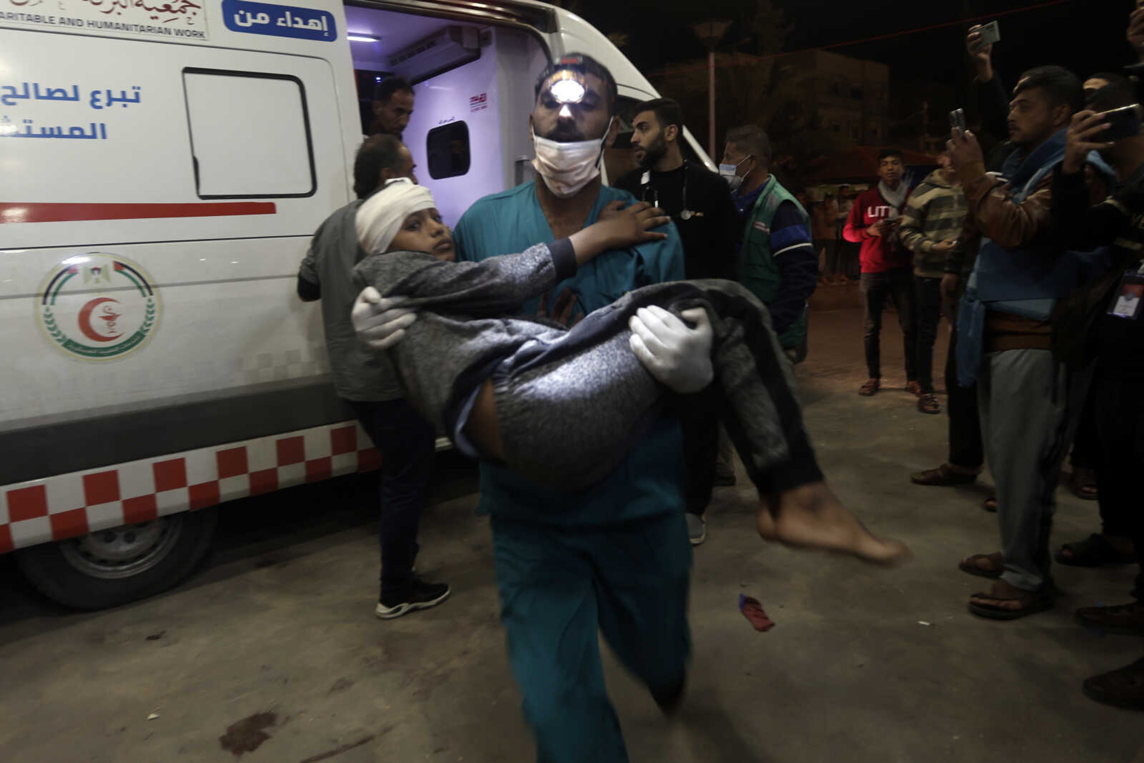 A wounded Palestinian boy is carried into the Nasser Hospital following Israeli bombardment on Khan Younis refugee camp Monday in southern Gaza Strip.