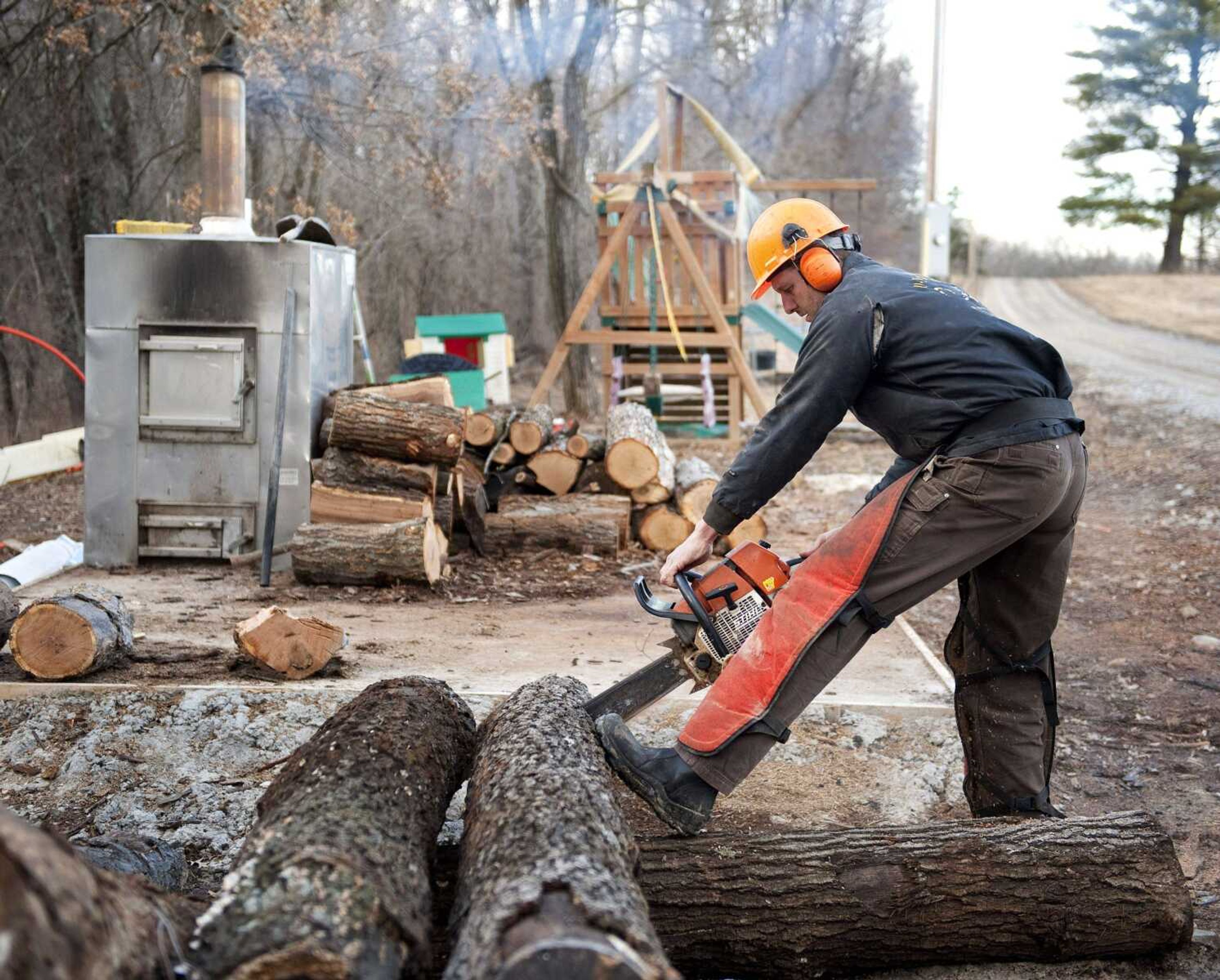 Darwin Woods cuts wood Friday for his wood-burning stove he uses to heat his workshop at his home near Clark, Mo. 
(L.G. Patterson ~ Associated Press)