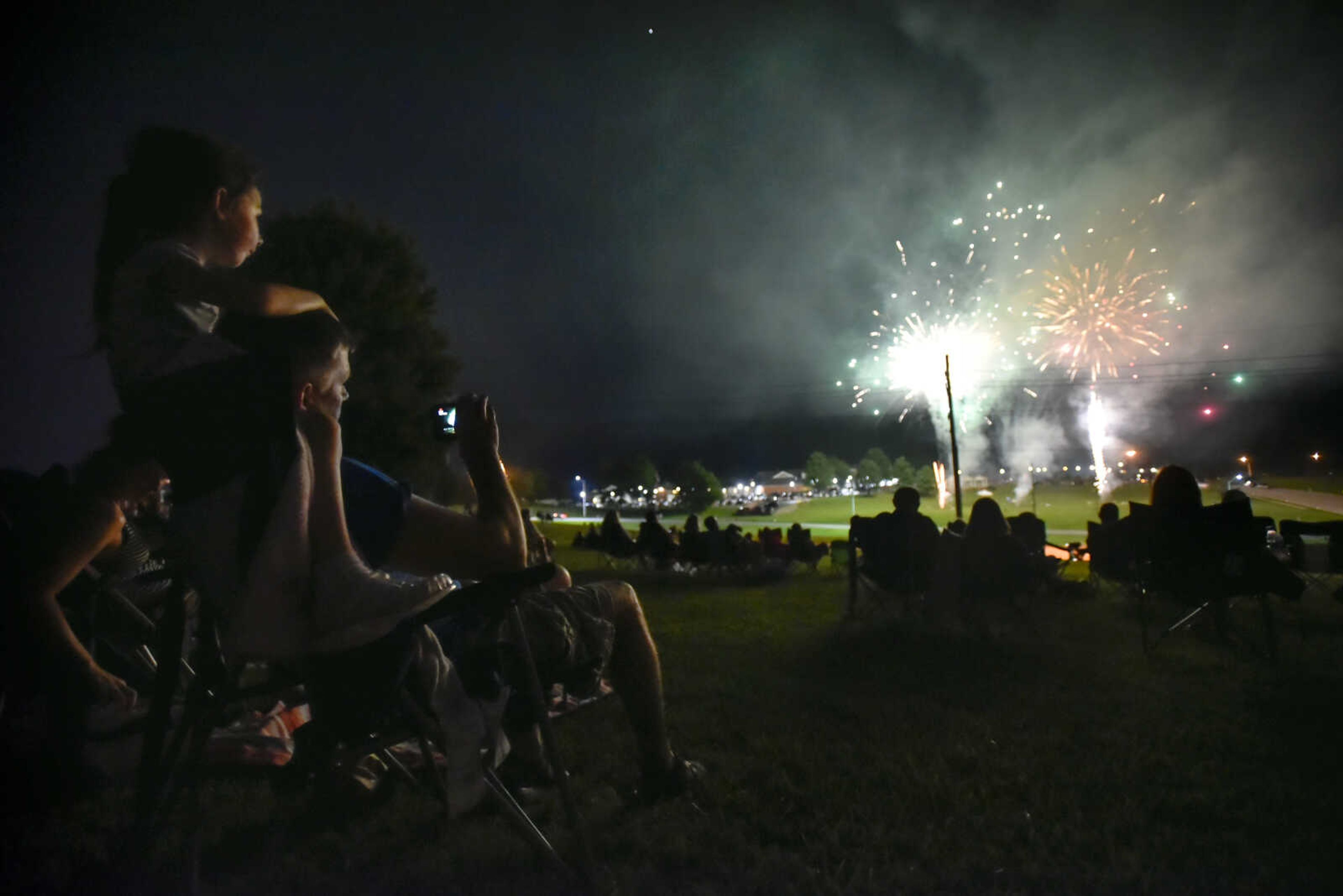 Blair, 4, top left, watches the Missouri Veterans Home fireworks show from the Cape County Park North lawn with Kevin Stacy on Tuesday, July 3, 2018, in Cape Girardeau.