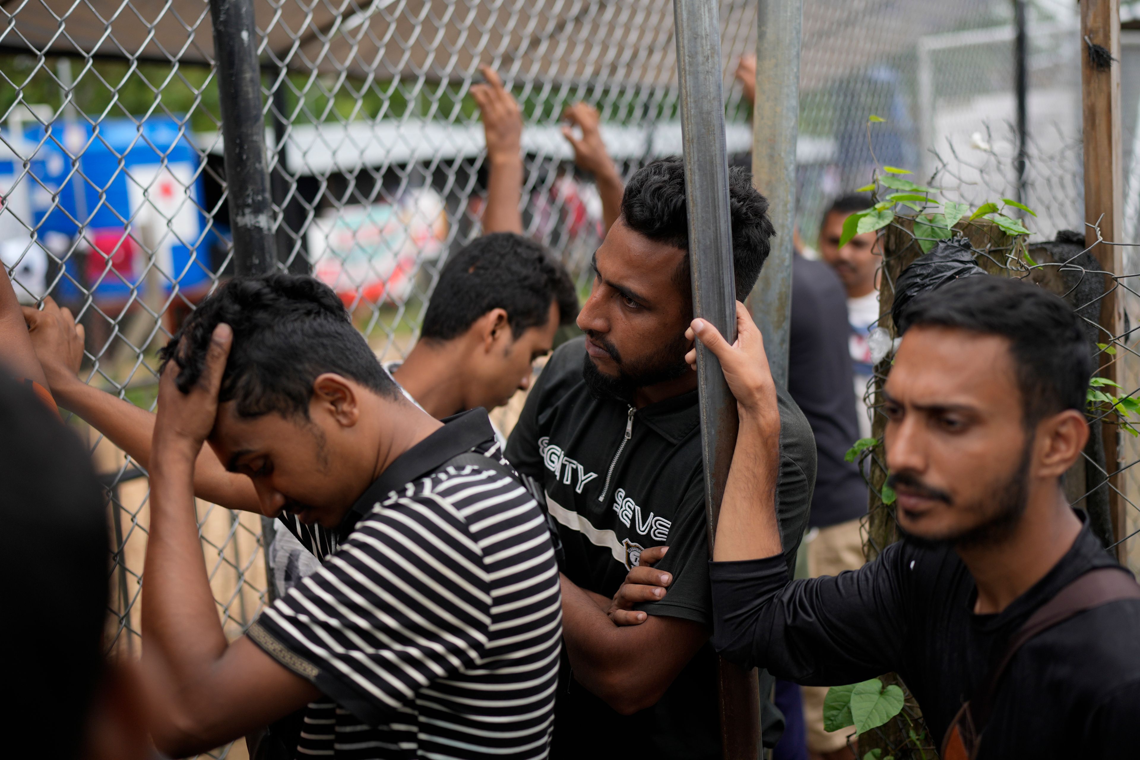 Migrants from Bangladesh wait at an immigration post where Panamanian officers process the identifications of those who have trekked across the Darién Gap, in Lajas Blancas, Panama, Thursday, Sept. 26, 2024. (AP Photo/Matias Delacroix)