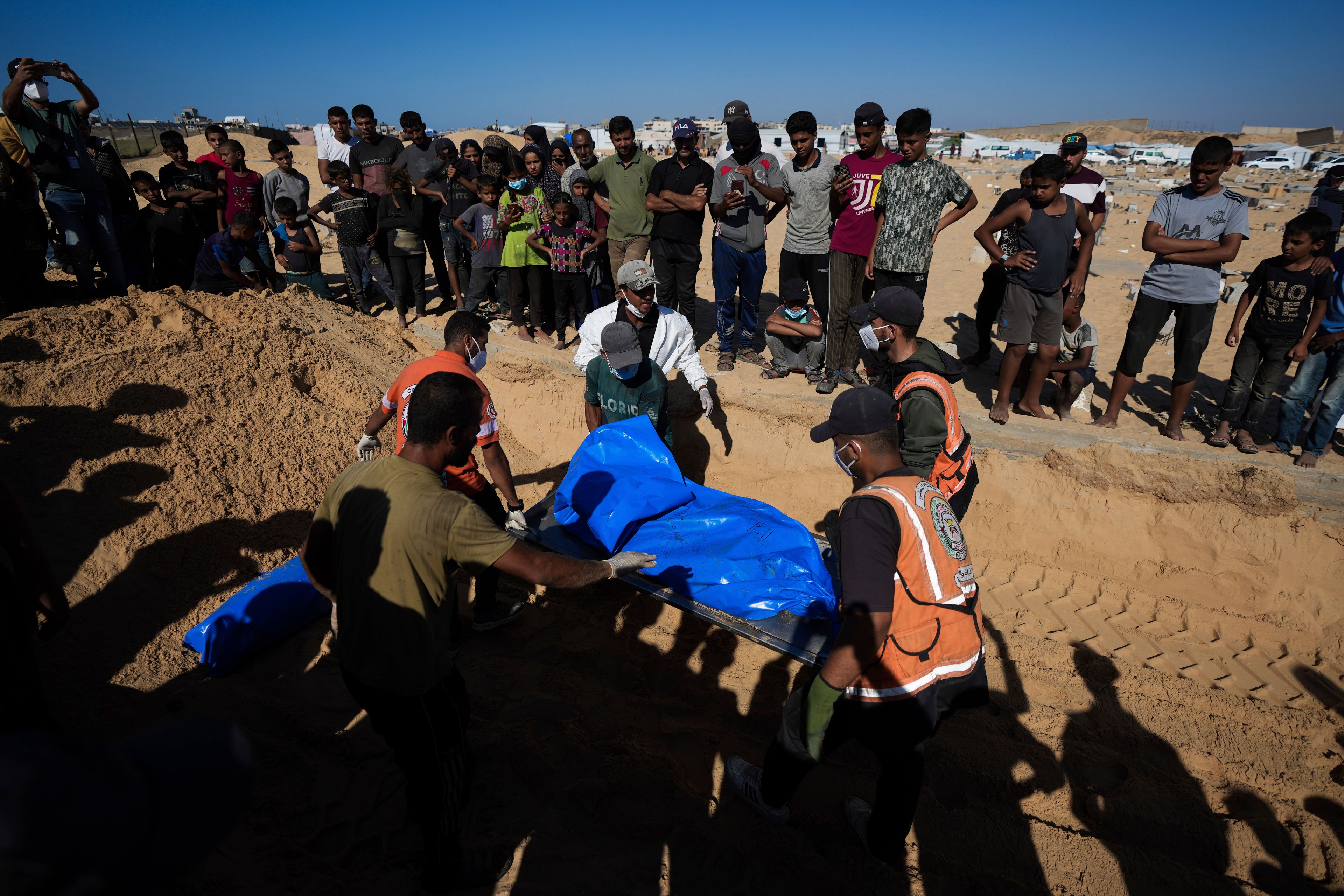 People bury the bodies of Palestinians taken by the Israeli military during operations in Gaza and returned this week, in Khan Younis, Gaza Strip, Thursday, Sept. 26, 2024. (AP Photo/Abdel Kareem Hana)