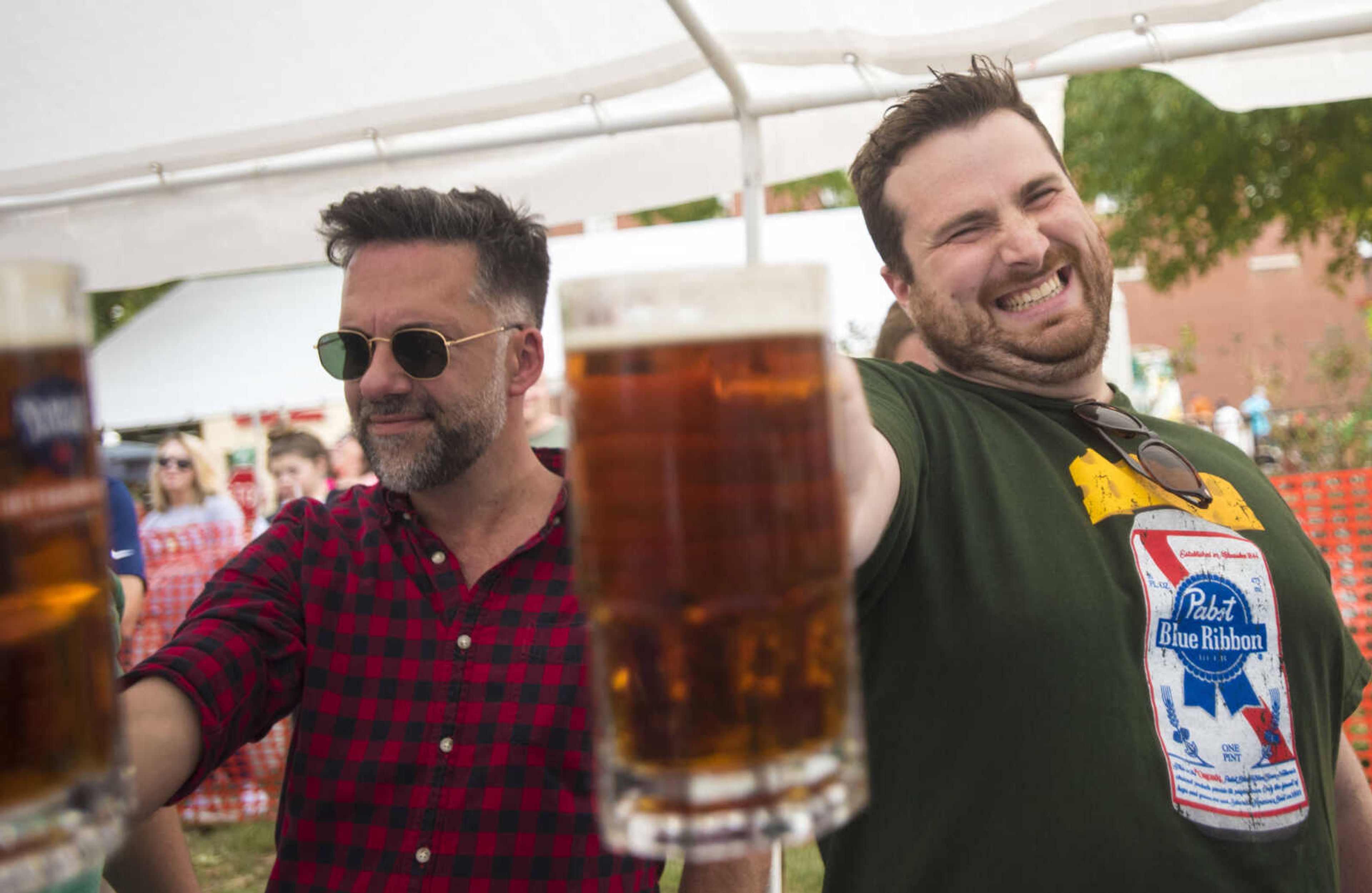 Dwight Stamp, left, and Travis Randolph, right, compete in the Sam Adams Stein Hoisting at the Uptown Jackson Oktoberfest, Saturday, October 7, 2017.