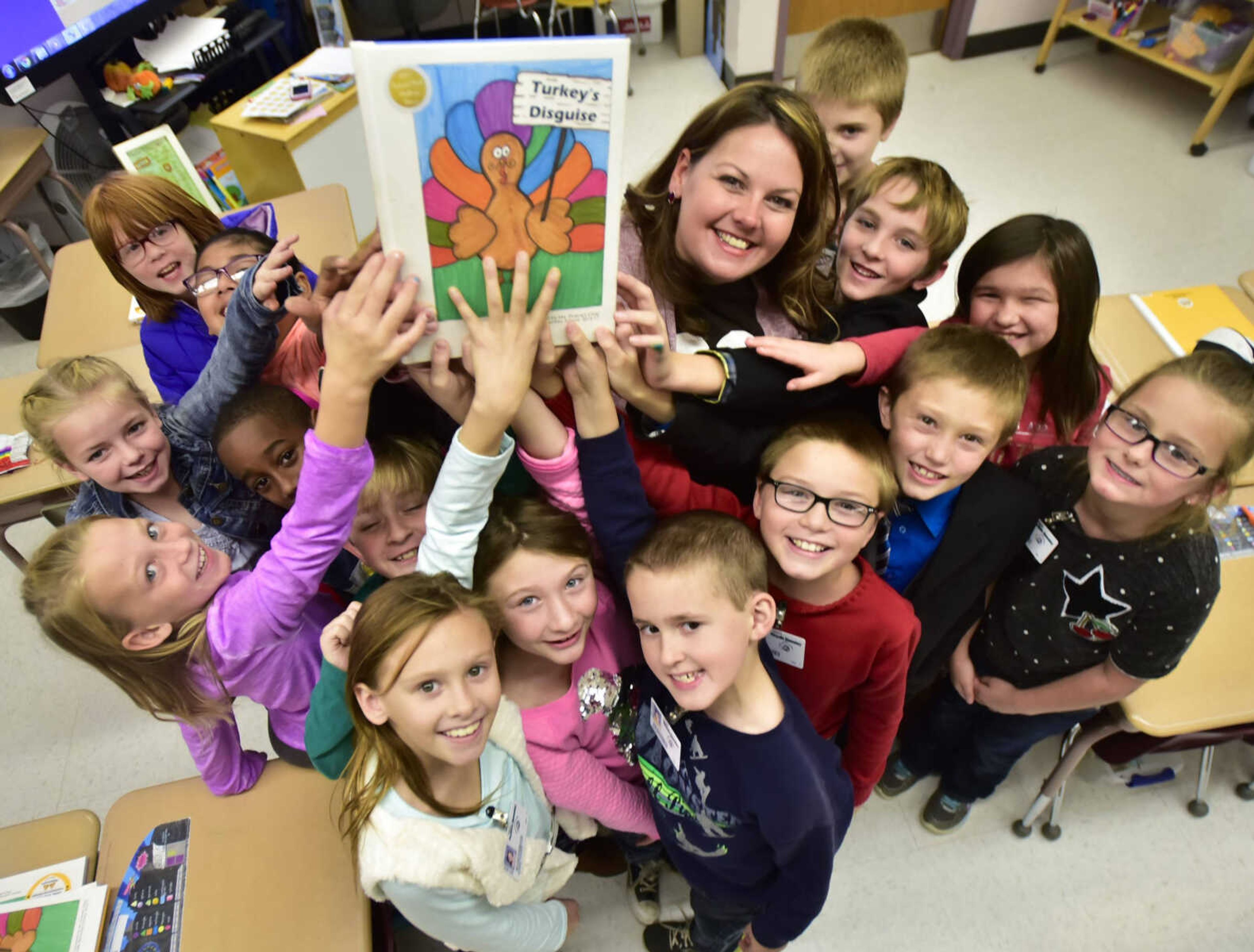 Valerie Stueve and her former second-grade students hold a copy of their book, "Turkey's Disguise," on Tuesday at Perryville Elementary School in Perryville, Missouri.