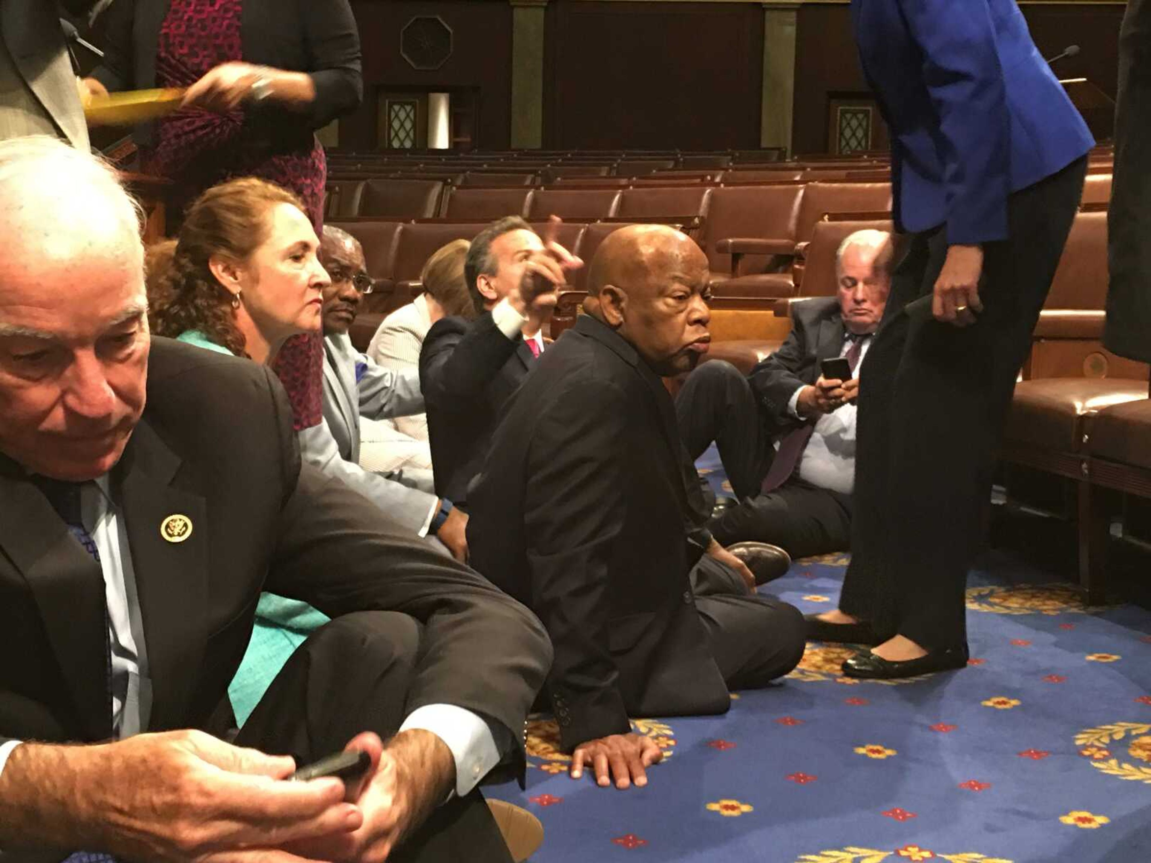 Democratic members of Congress, including Rep. John Lewis, D-Ga., center, and Rep. Joe Courtney, D-Conn., left, participate in a sit-down protest Wednesday seeking a vote on gun-control measures on the floor of the House on Capitol Hill in Washington.