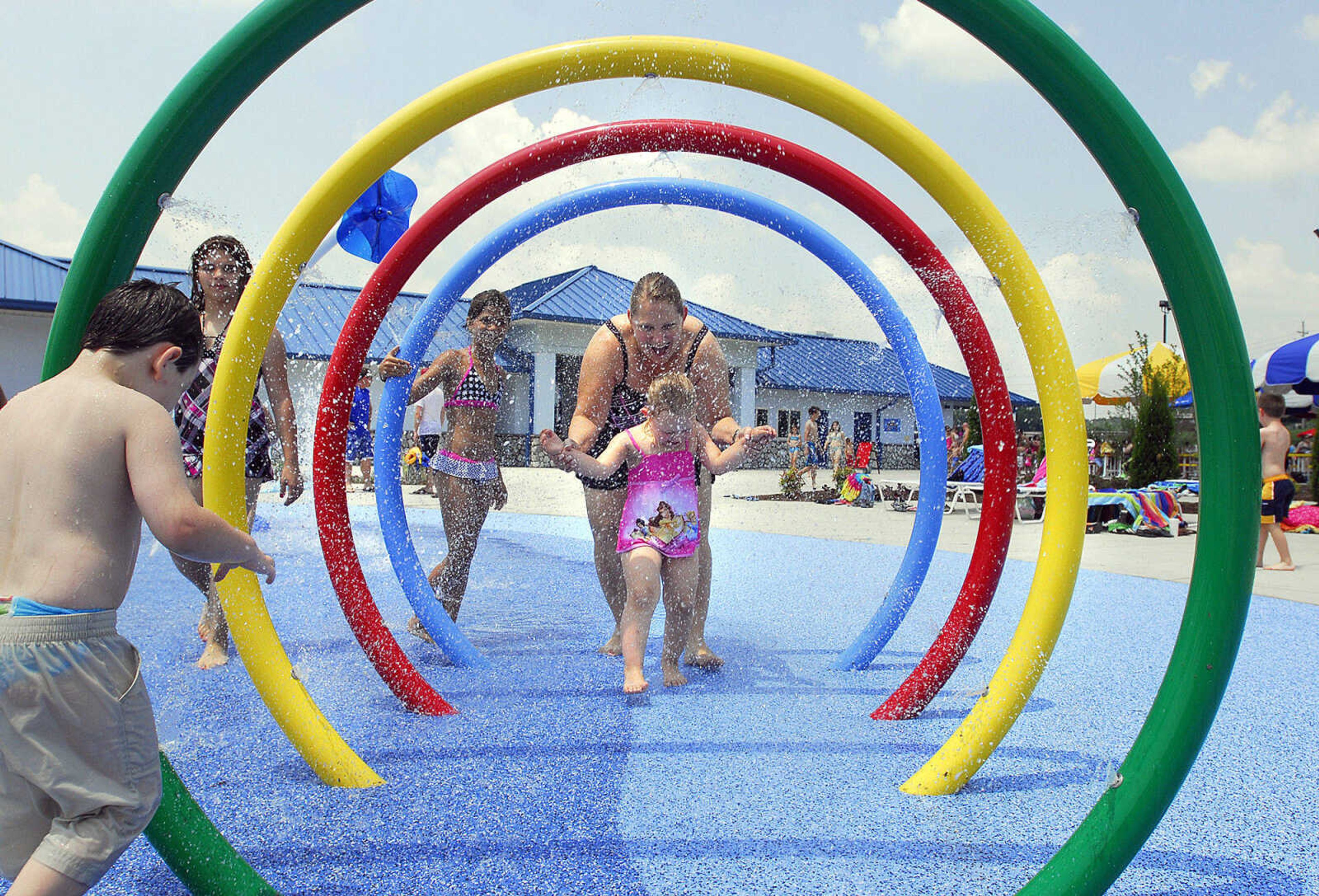 LAURA SIMON~lsimon@semissourian.com
Robin Koetting and her three-year-old daughter Audrey run through the spray rings on the spray pad Saturday, May 29, 2010 during the opening day of Cape Splash Family Aquatic Center. The center features a spray pad, vortex, 700 foot lazy river, two open and enclosed flumes, six-lane lap pool, and a leisure pool.  Cape Splash is open from 11-7 seven days a week.