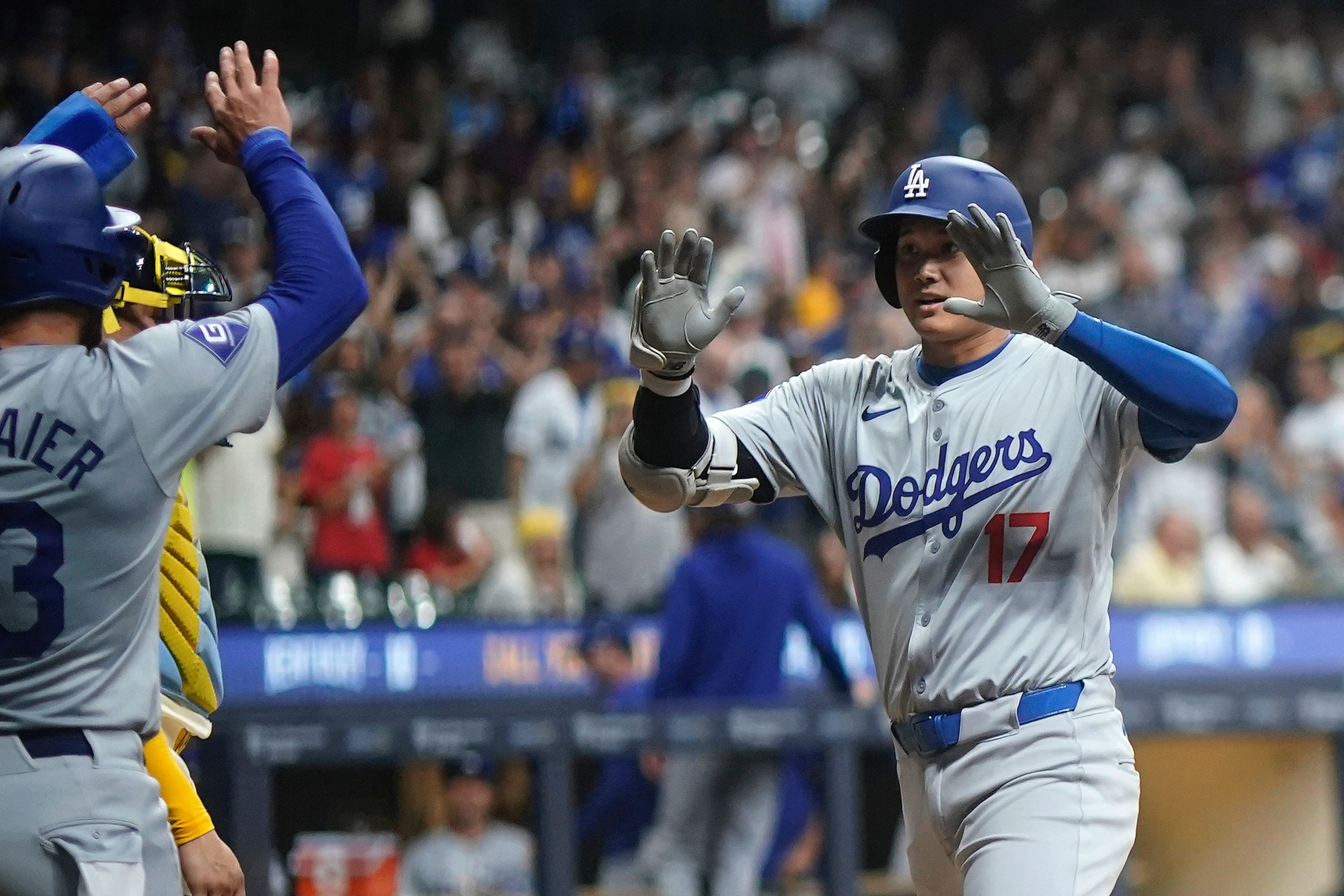 Los Angeles Dodgers' Shohei Ohtani (17) is congratulated by teammates after hitting a two-run home run during the fifth inning of a baseball game against the Milwaukee Brewers, Monday, Aug. 12, 2024, in Milwaukee. (AP Photo/Aaron Gash)