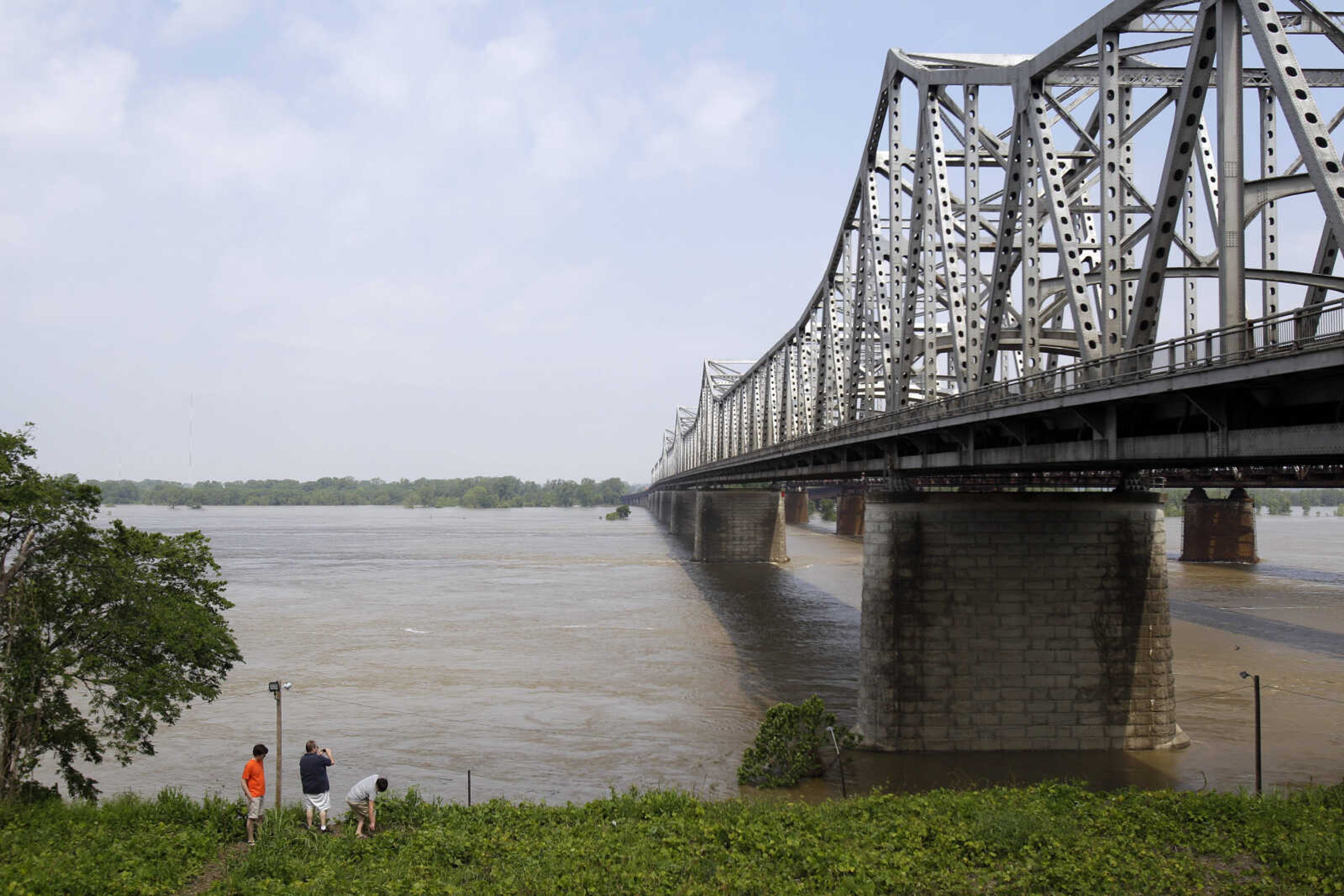 People stand at the base of the Interstate 55 bridge crossing the Mississippi River to get a better look at flooding Sunday, May 8, 2011, in Memphis, Tenn. More Memphis residents were being told Sunday to flee their homes for higher ground as the mighty Mississippi River edged toward the city, threatening to bring more flooding to parts of an area already soaked. (AP Photo/Jeff Roberson)