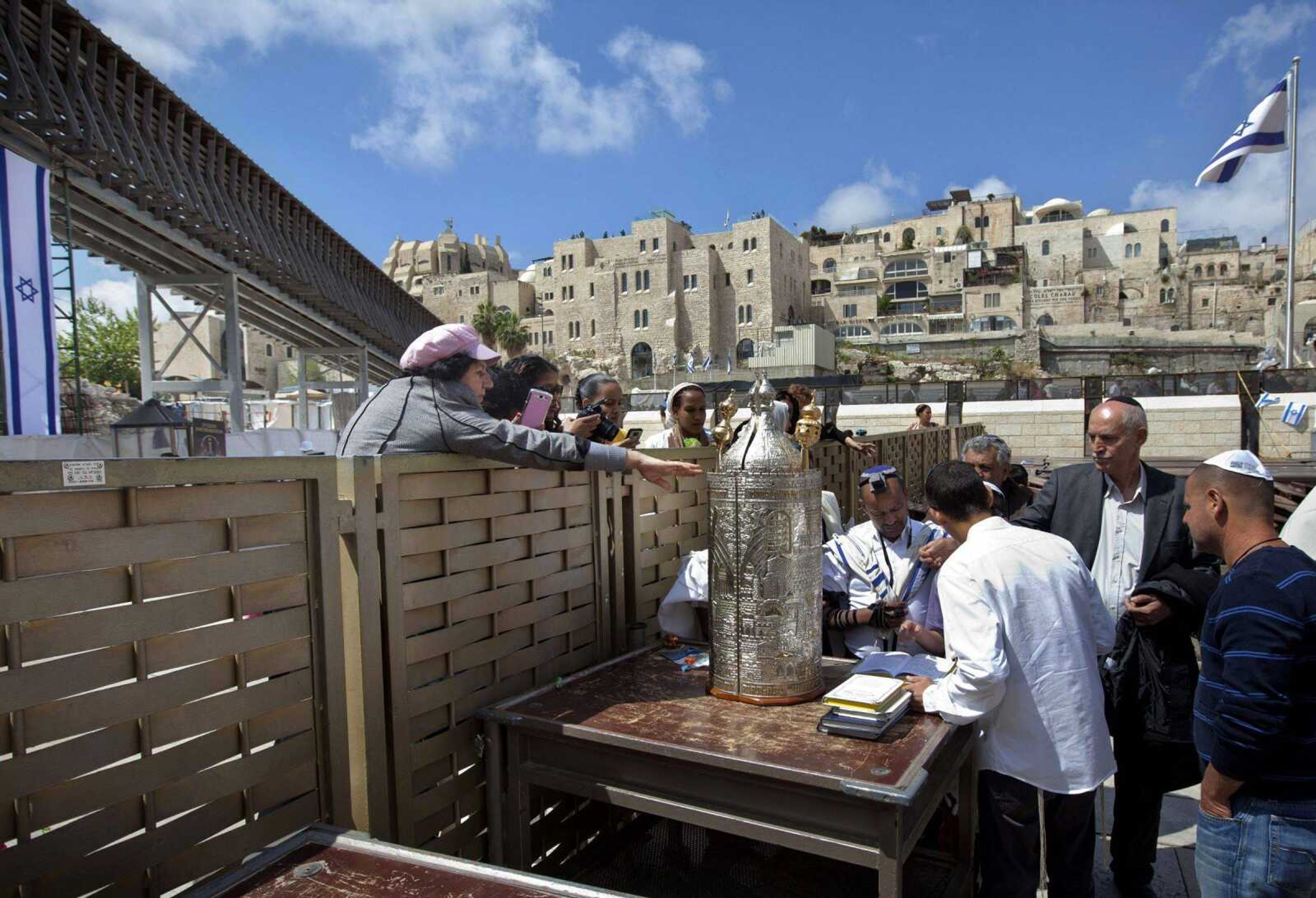 A woman reaches to touch a Torah scroll across a fence at the Western Wall, the holiest site where Jews can pray in Jerusalem&#8217;s old city, on Wednesday. (Sebastian Scheiner ~ Associated Press)