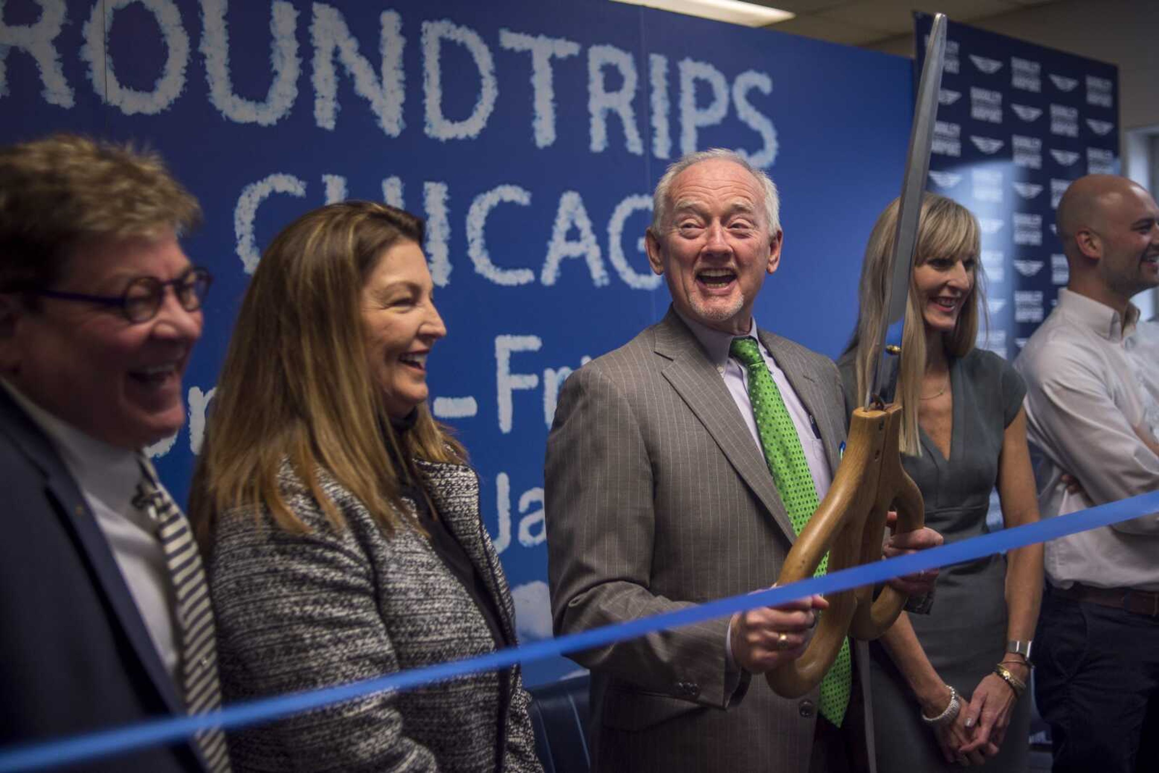 George Bray, center, chairman of the airport board for Barkley Regional Airport, laughs while preparing to cut a ceremonial ribbon with oversiz scissors Jan. 7 after the first flight from Cape Girardeau to Paducah, Kentucky.