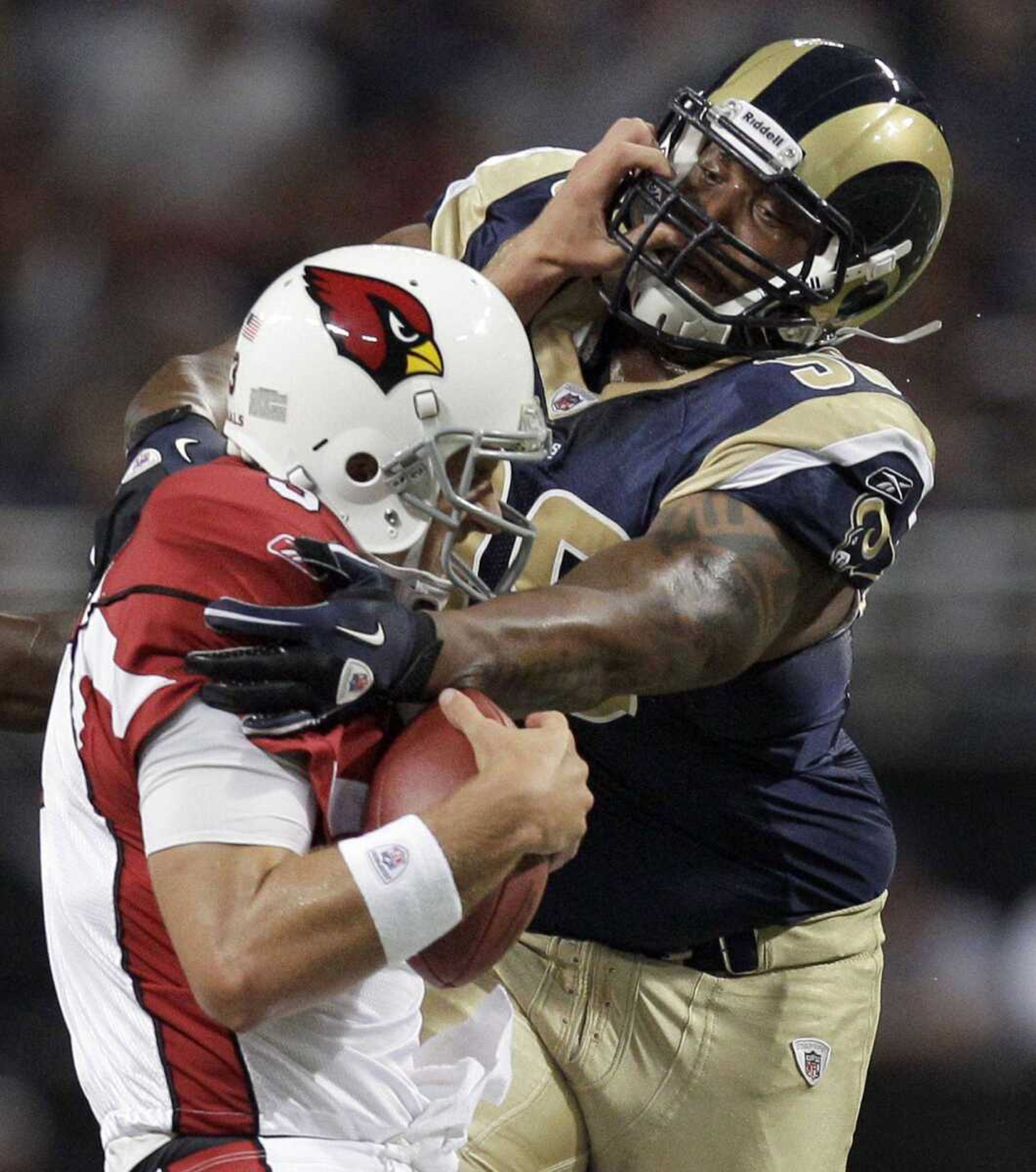 ABOVE: Rams defensive tackle Fred Robbins sacks Cardinals quarterback Derek Anderson during the first quarter Sunday in St. Louis. TOP: Rams rookie quarterback Sam Bradford passes during the first quarter. (Jeff Roberson ~ Associated Press)