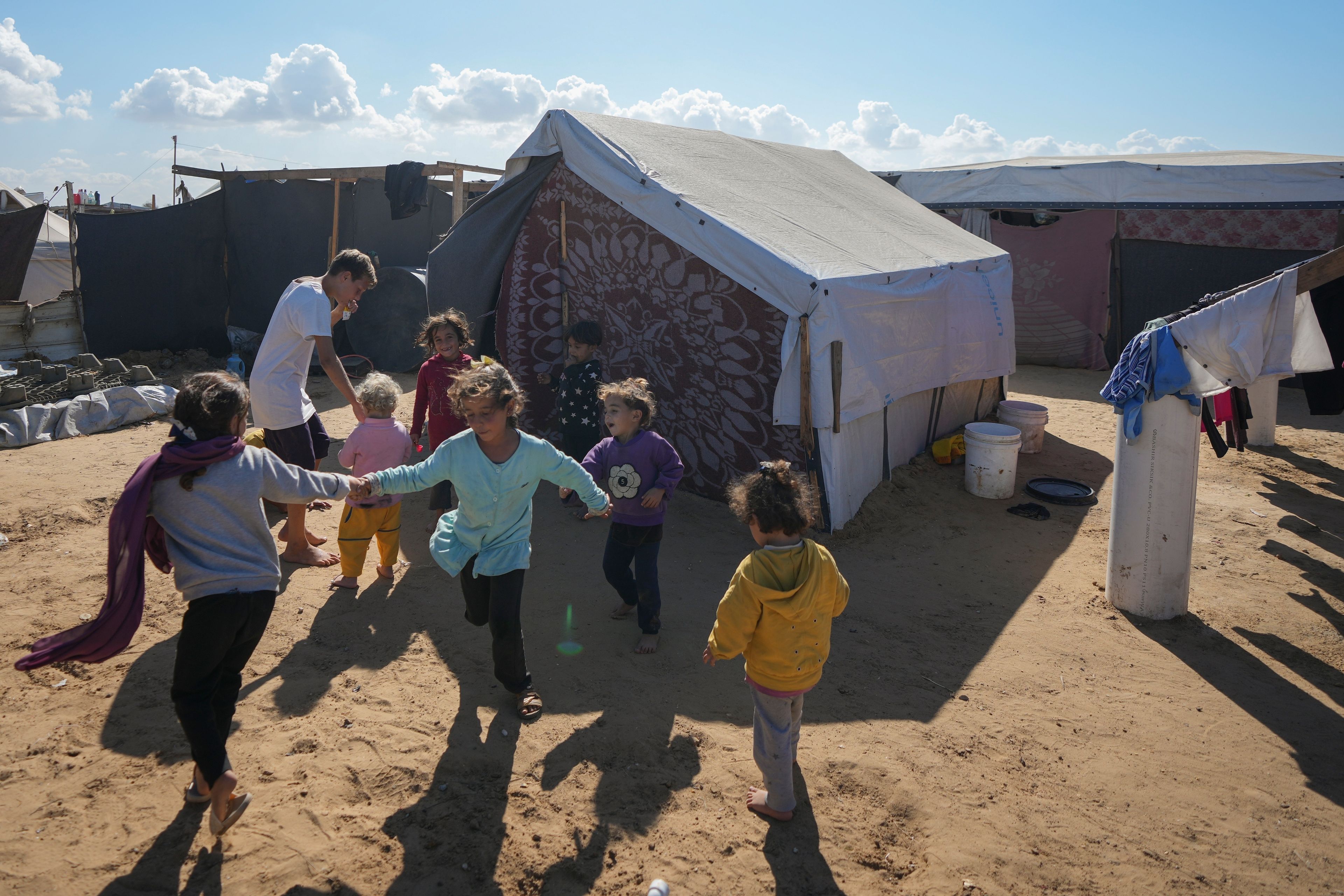 Children play next to their tent in a refugee camp in Deir al-Balah, Gaza Strip, Tuesday Nov. 19, 2024. (AP Photo/Abdel Kareem Hana)