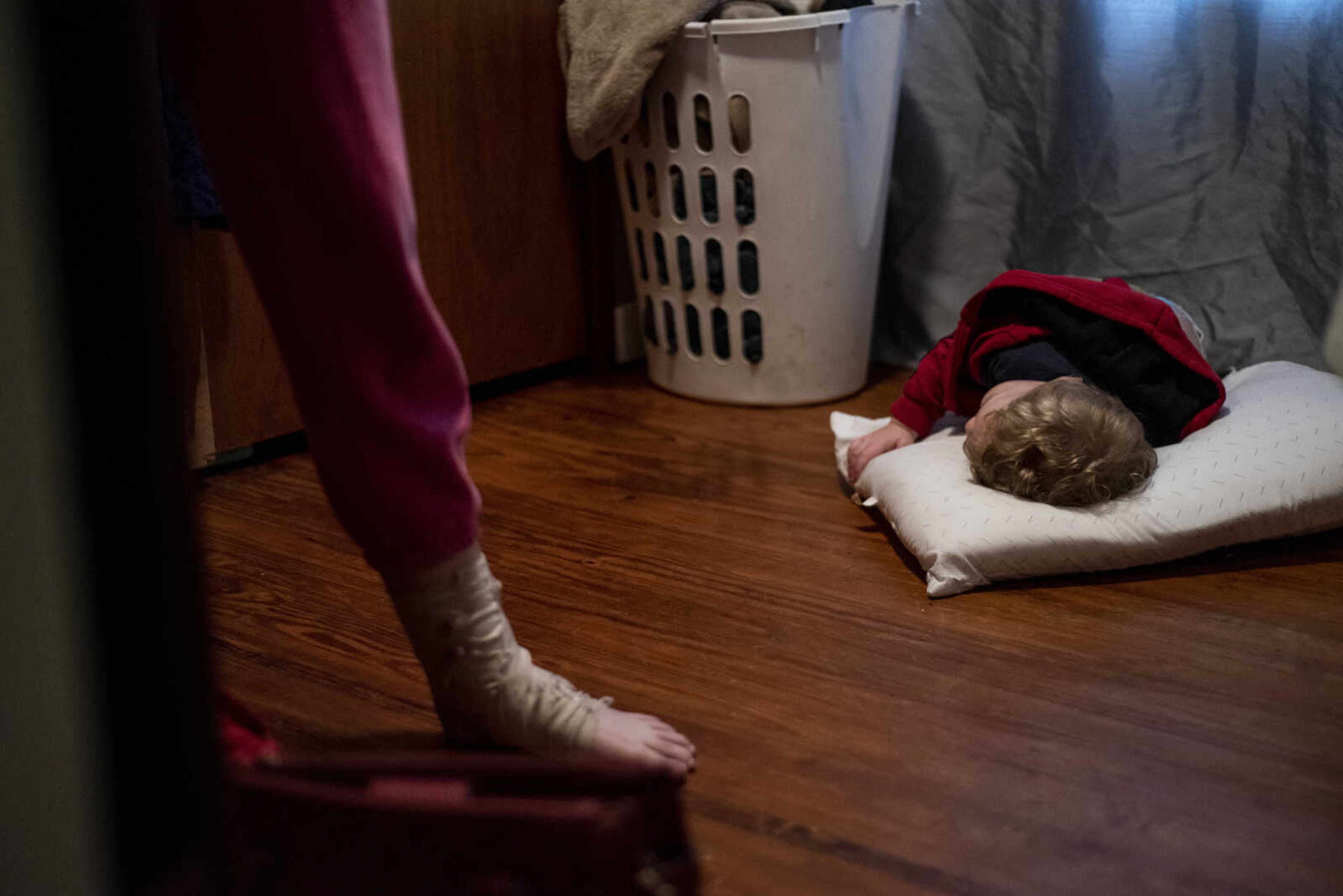 Phoenix Young, 2, lies down on a pillow he dragged into the room where his mom, Emily Medlock, was getting ready for graduation Sunday, May 12, 2019, at home in Cape Girardeau.