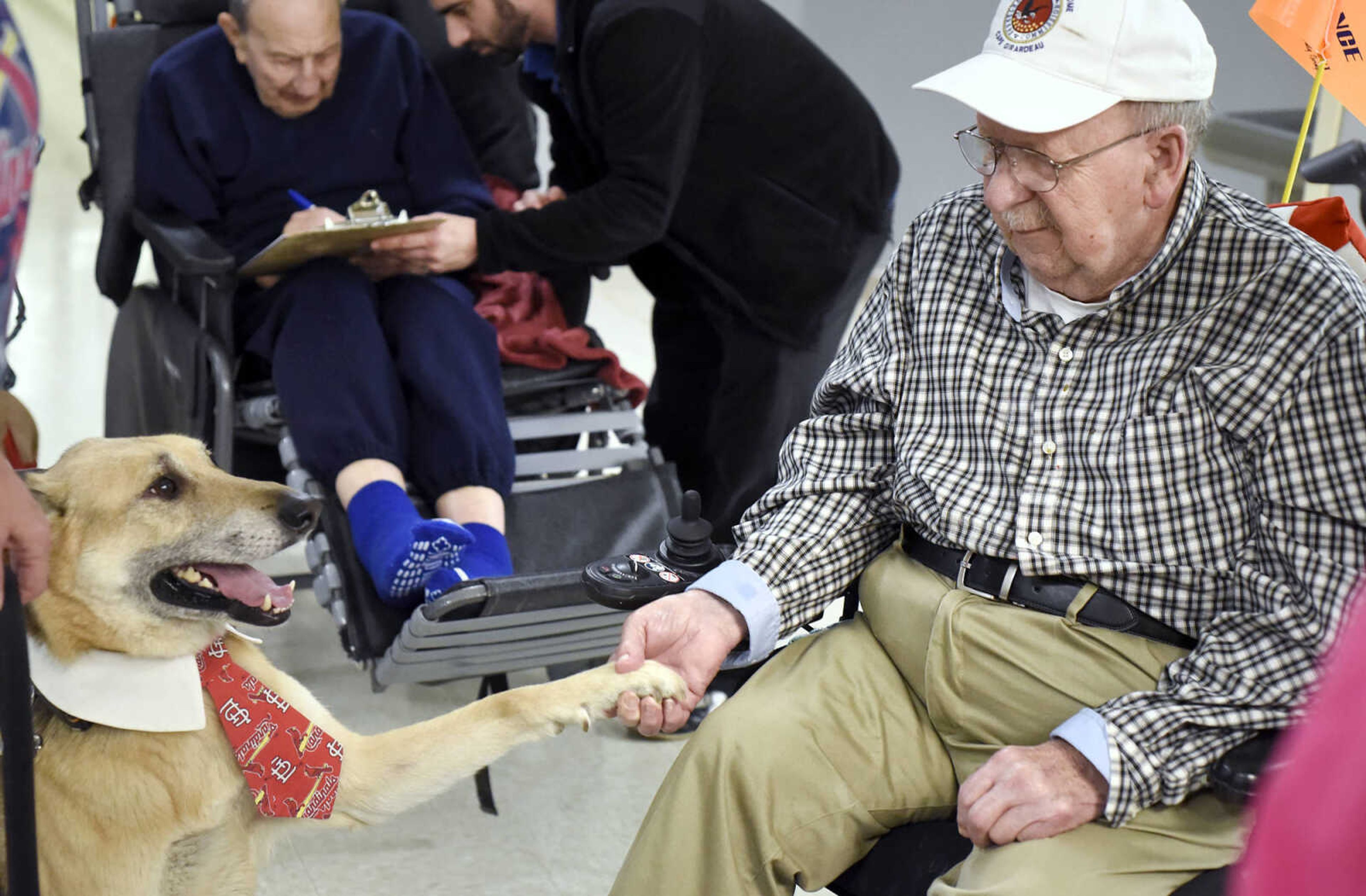 Carl Henneke shakes Max's hand on Tuesday, Feb. 21, 2017, during the Pet Pals visit at the Missouri Veteran's Home in Cape Girardeau.