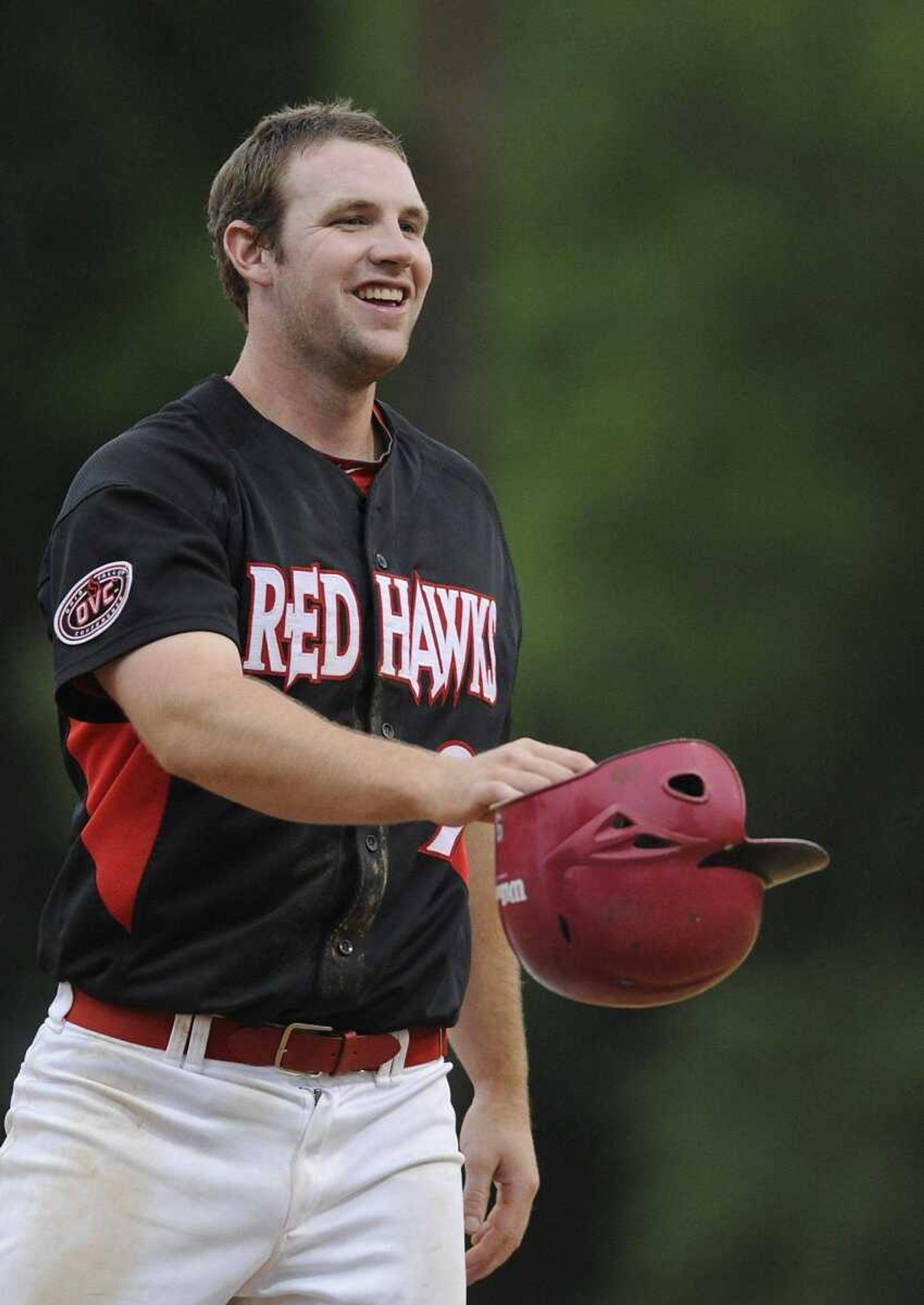 Southeast Missouri State third baseman Trenton Moses hands his batting helmet off before taking the field after being stranded on base during Friday's game.