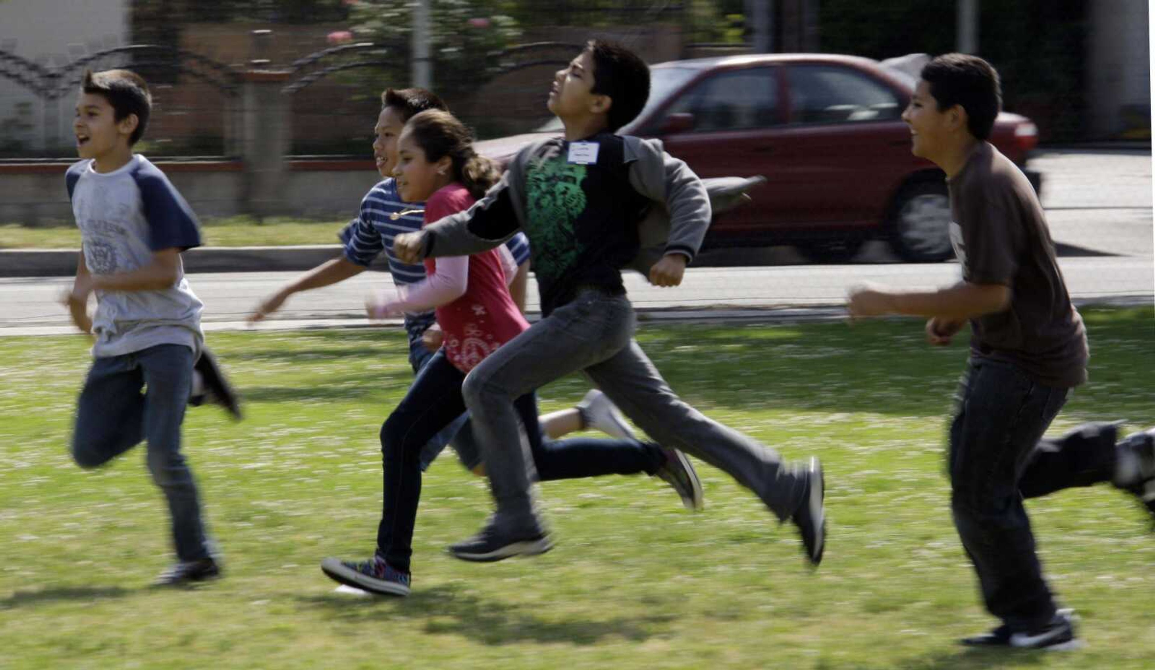 FILE - This May 10, 2011 file photo shows children at Tracy Elementary School running across a field as they take part in after-school exercise activities on the campus in Baldwin Park, Calif. Reading, writing, `rithmetic _ and PE? The prestigious Institute of Medicine is recommending that schools provide opportunities for at least 60 minutes of physical activity each day for students and treat physical education as a core subject. The report says only about half of the nation's youngsters are getting at least an hour of vigorous or moderate physical activity every day. (AP Photo/Reed Saxon, File)