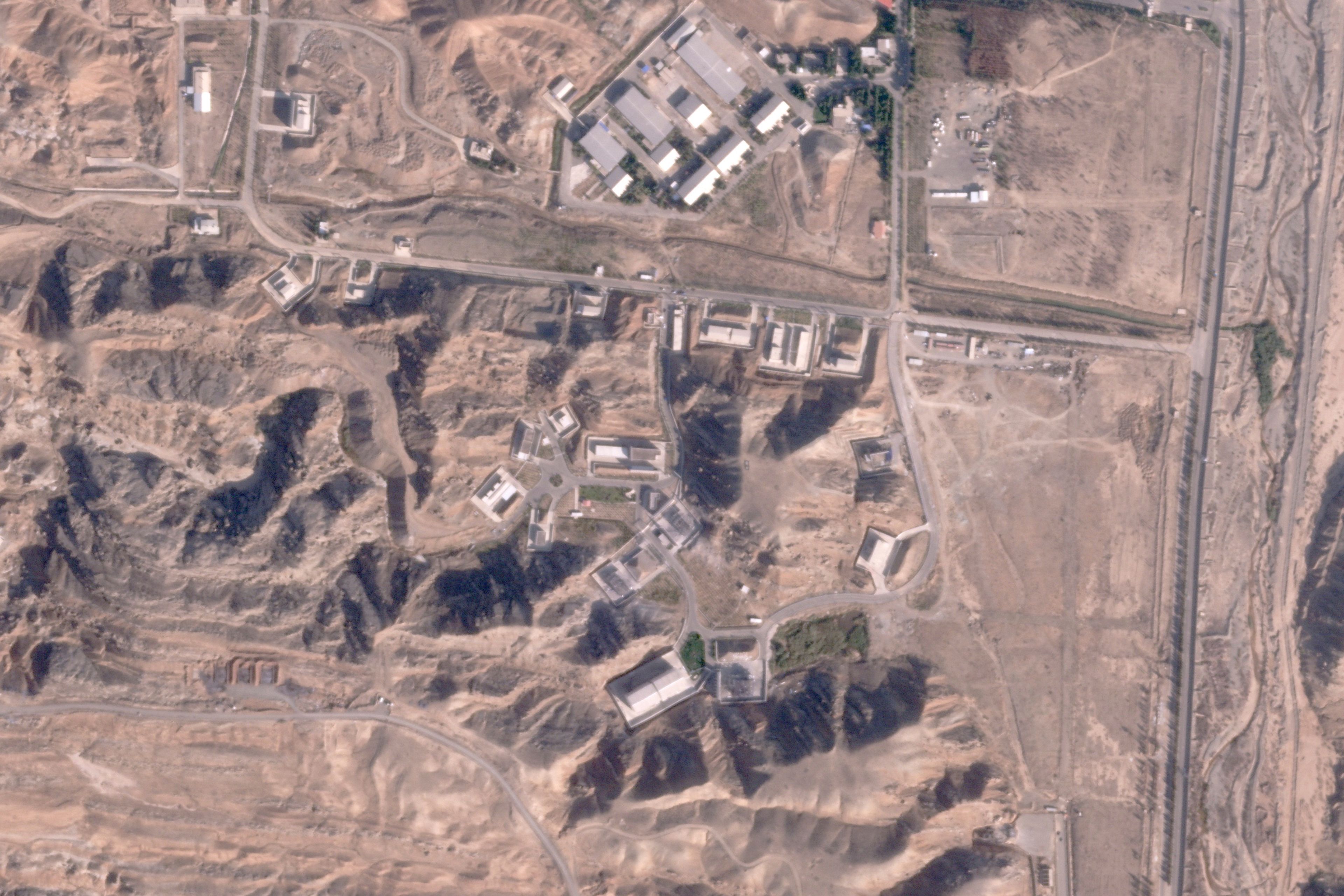 This satellite photo from Planet Labs PBC shows damaged buildings at Iran's Parchin military base outside of Tehran, Iran, Sunday, Oct. 27, 2024. An Israeli attack on Iran damaged facilities at a secretive military base southeast of the Iranian capital that experts in the past have linked to Tehran's onetime nuclear weapons program and at another base tied to its ballistic missile program, satellite photos analyzed Sunday by The Associated Press show. The damaged structures are in the bottom right corner and bottom center of the image. (Planet Labs PBC via AP)