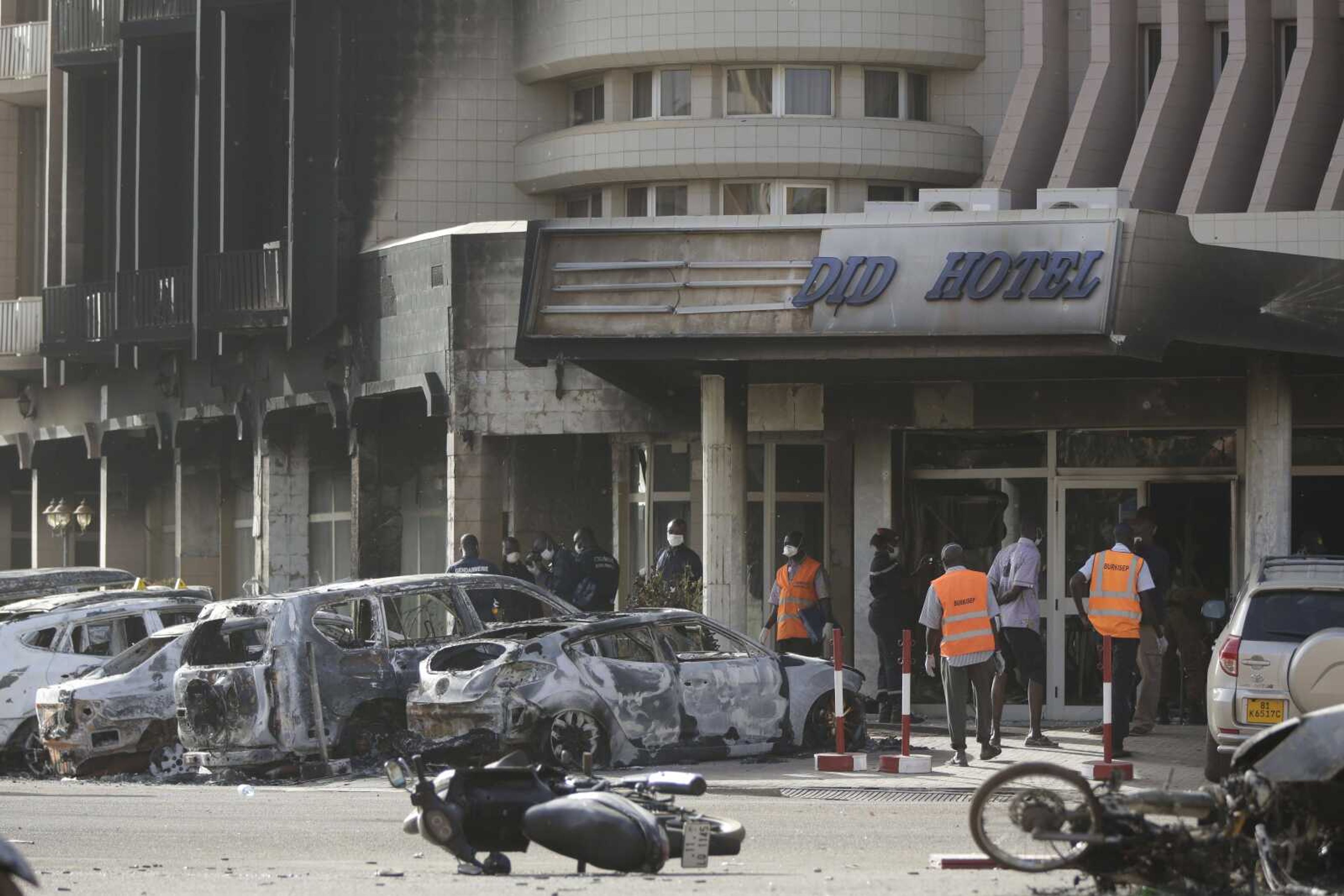 Rescue workers inspect damaged cars Saturday at the entrance of the Splendid Hotel in Ouagadougou, Burkina Faso. (Sunday Alamba ~ Associated Press)