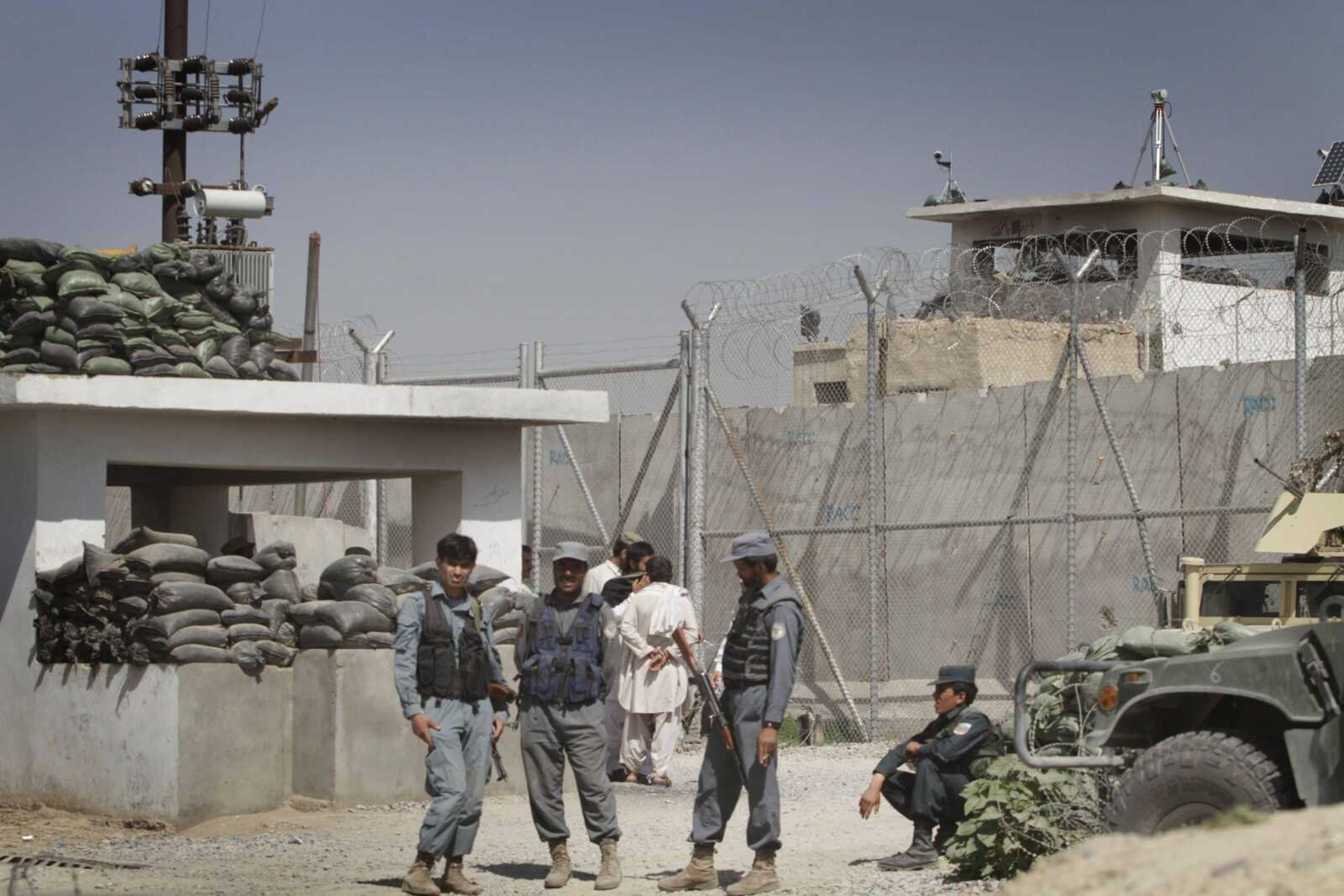 Afghan policemen stand in front of gate of the main prison in Kandahar, south of Kabul, Afghanistan on Monday, April 25, 2011. Taliban insurgents dug a more than 1,050-foot (320-meter) tunnel underground and into the main jail in Kandahar city and whisked out more than 450 prisoners, most of whom were Taliban fighters, officials and the insurgents said Monday. (AP Photo/Allauddin Khan)