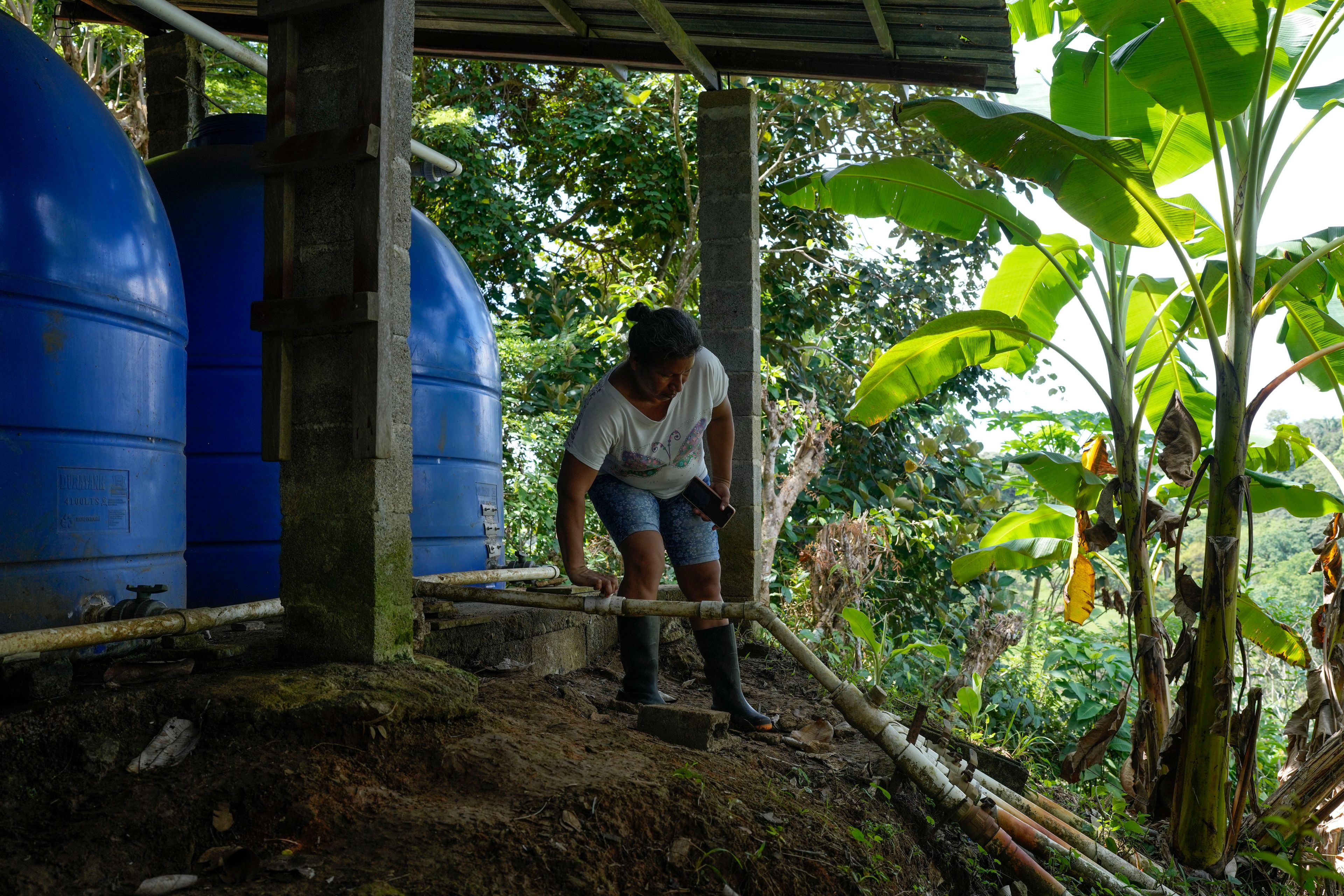 Ilda Rodriguez turns on a faucet to distribute water to La Represa neighborhood in Colon, Panama, Monday, Sept. 2, 2024. Under a proposed plan to dam the nearby Indio River and secure the Panama Canal's uninterrupted operation, the community would gain more reliable access to water. (AP Photo/Matias Delacroix)