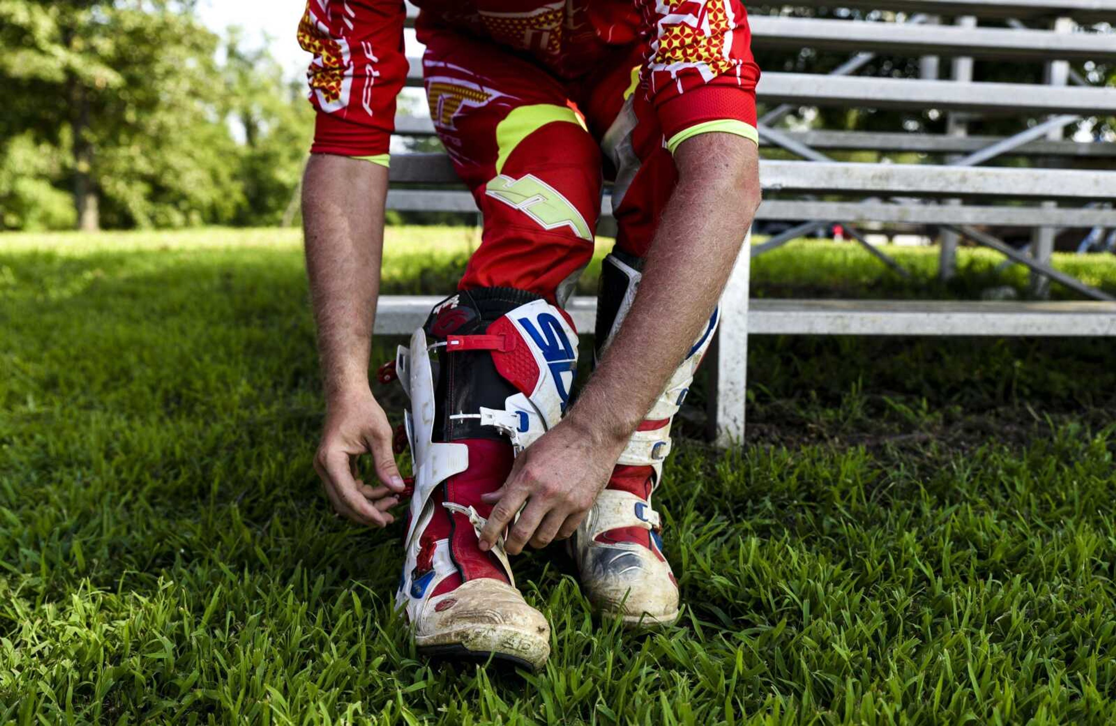 Austin Roberts, of Cape Girardeau, buckles his riding boots before an open practice session at Sky High Motocross Park July 4 in Old Appleton.