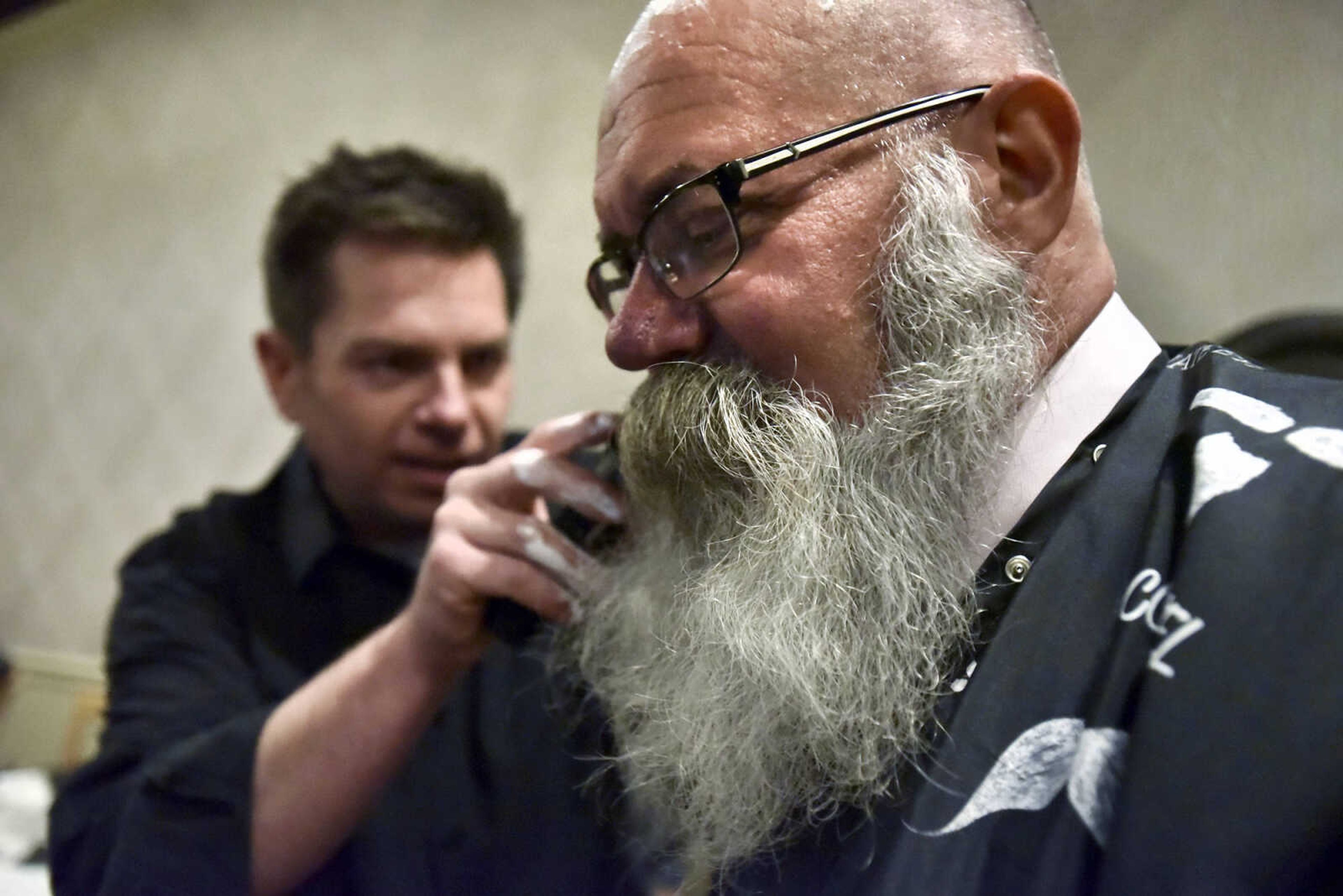 LAURA SIMON ~ lsimon@semissourian.com

Rex Rust, co-president of Rust Communications, shaves Dave Hutson's beard Wednesday, Nov. 16, 2016, at Port Cape in downtown Cape Girardeau. Hutson started growing his beard Nov. 1, 2015 to help raise money for The Movember Foundation, which raises money for prostate cancer, depression and other health issues affecting men. Hutson auctioned off the chance to shave his beard during the annual Charles L. Hutson auction in September. The annual auction, started by Hutson's father, benefits Old Town Cape.