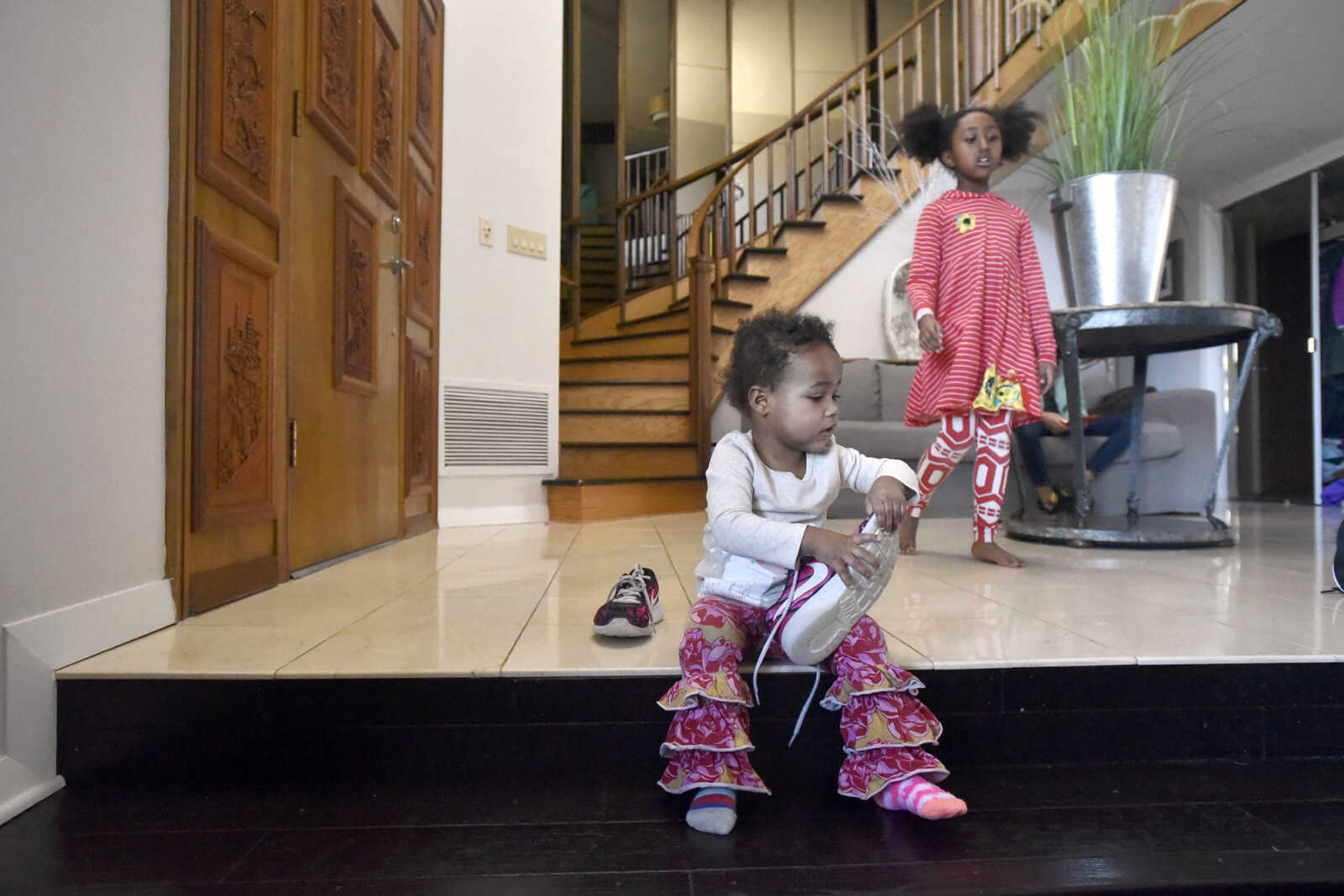 Lennyx Becking, 1, tries on her mother's shoes as her sister, Solie, 8, walks by on Saturday, Jan. 28, 2017, at the Becking's Cape Girardeau home.