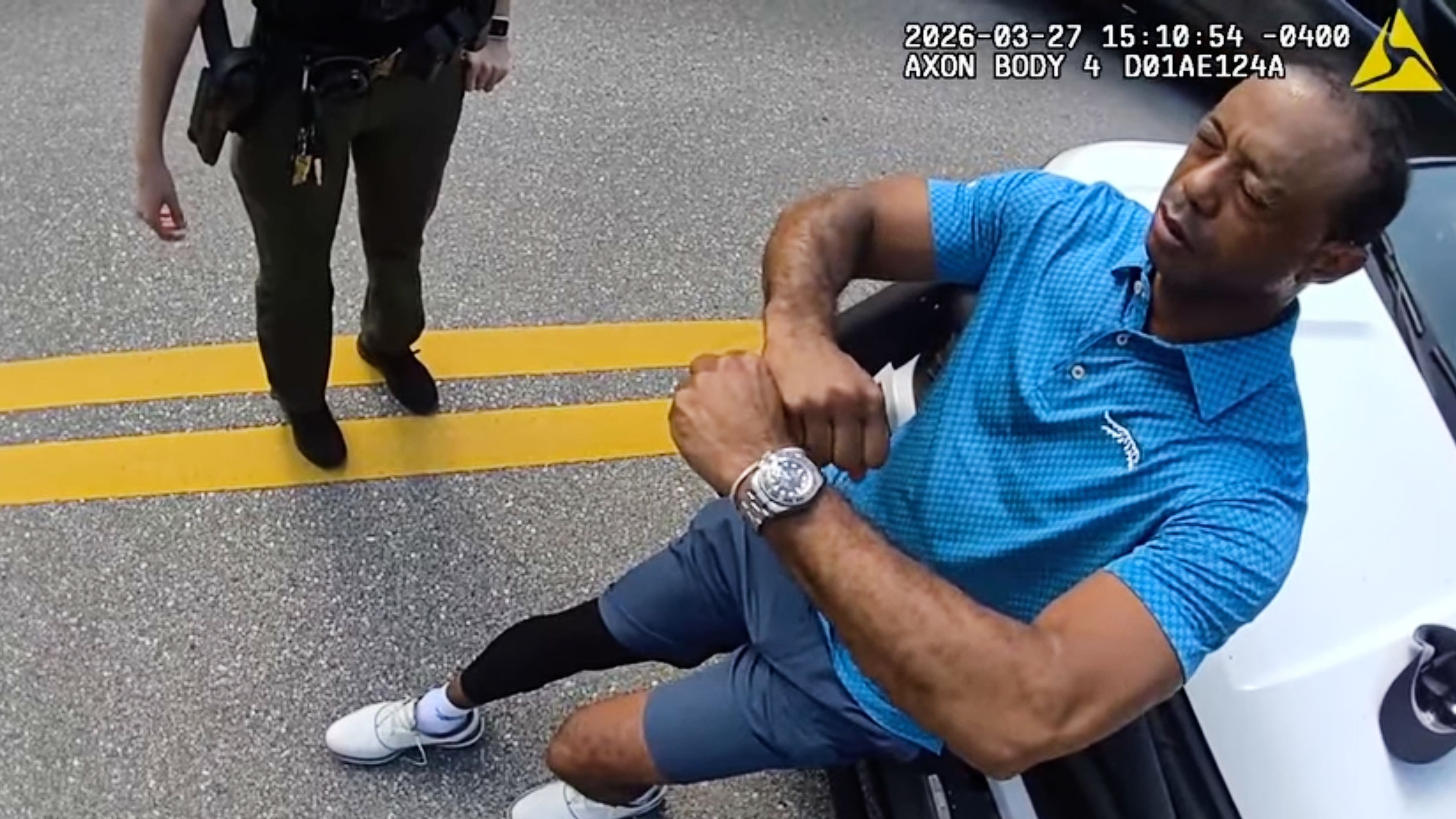 In this image taken from police body camera video released by the Martin County, Fla., Sheriff's Office, golfer Tiger Woods performs a field sobriety test for sheriff's deputies following a car crash in Jupiter Island, Fla., Friday, March 27, 2026. (Martin County Sheriff's Office via AP)