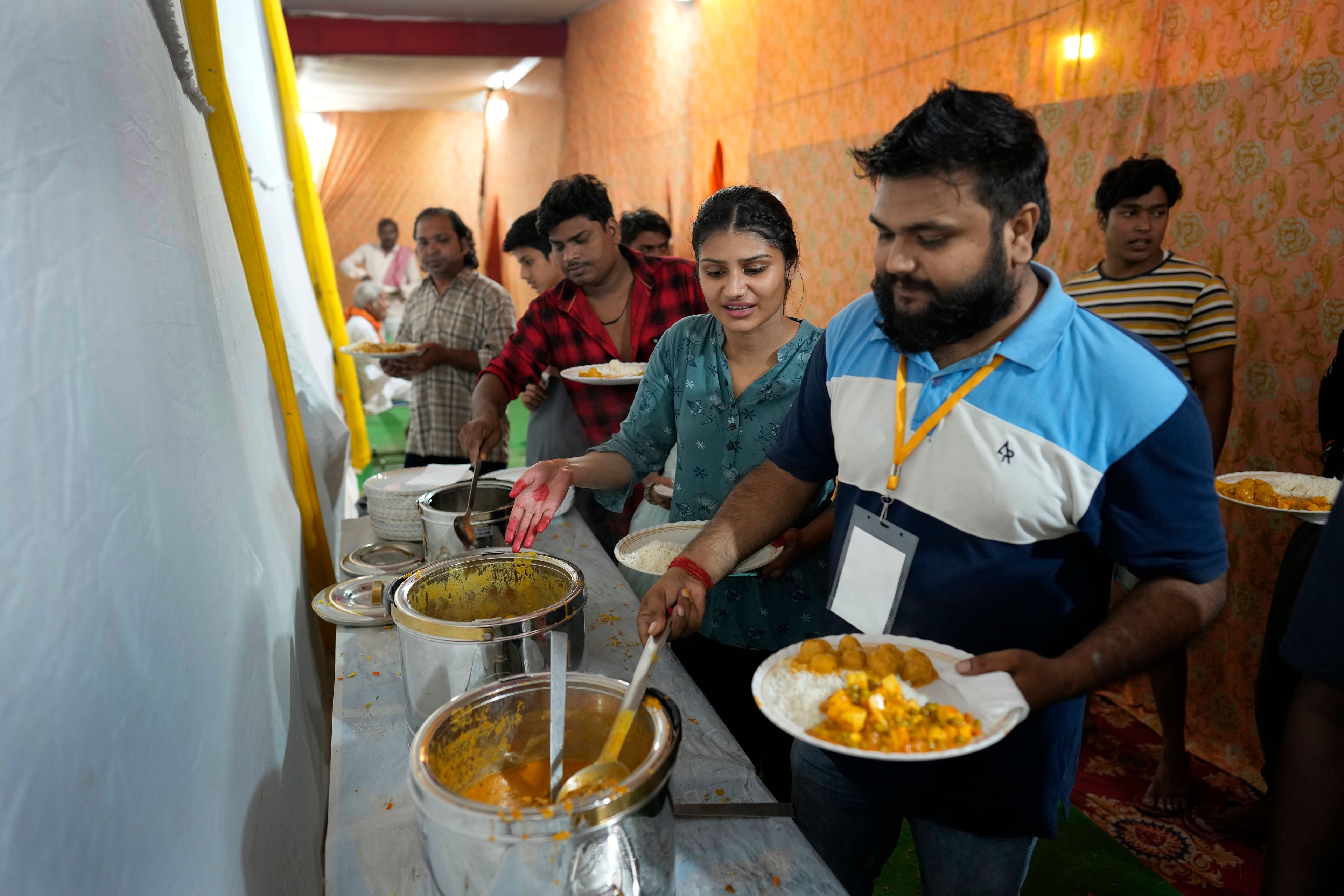 Hitanshi Jha, 21, an actor playing the character of Sita, second right, takes dinner with other actors after performing in Ramleela, a dramatic folk re-enactment of the life of Hindu god Rama according to the ancient Hindu epic Ramayana, in New Delhi, India, Wednesday, Oct. 9, 2024. (AP Photo/Manish Swarup)