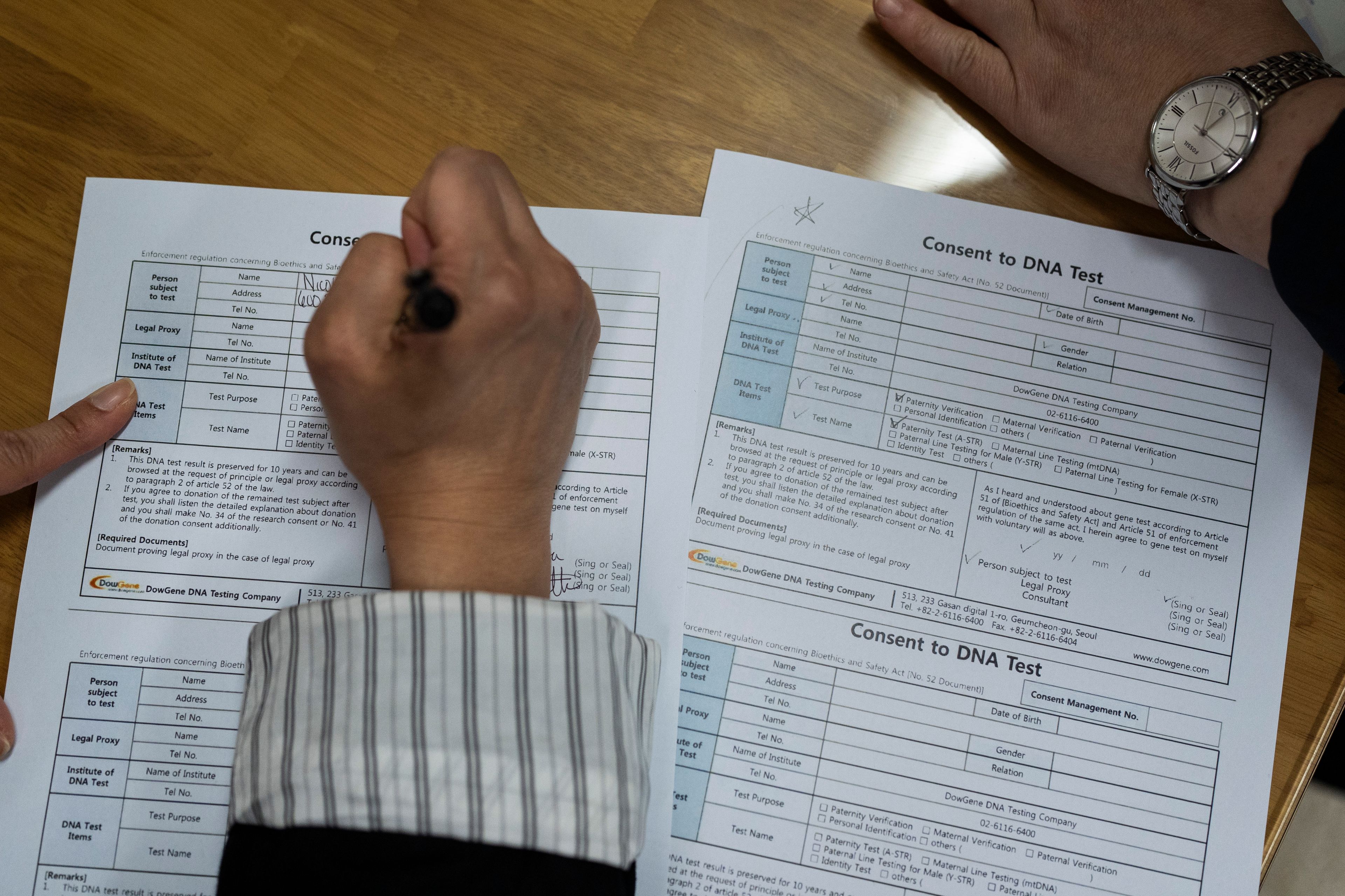 Nicole Motta, whose Korean name is Jang Hyeon-jung, fills out paperwork for a DNA test at the Eastern Social Welfare Society in Seoul, Friday, May 31, 2024, as she and her birth father are reunited for the first time since she was adopted by a family in Alabama, United States, in 1985. (AP Photo/Jae C. Hong)