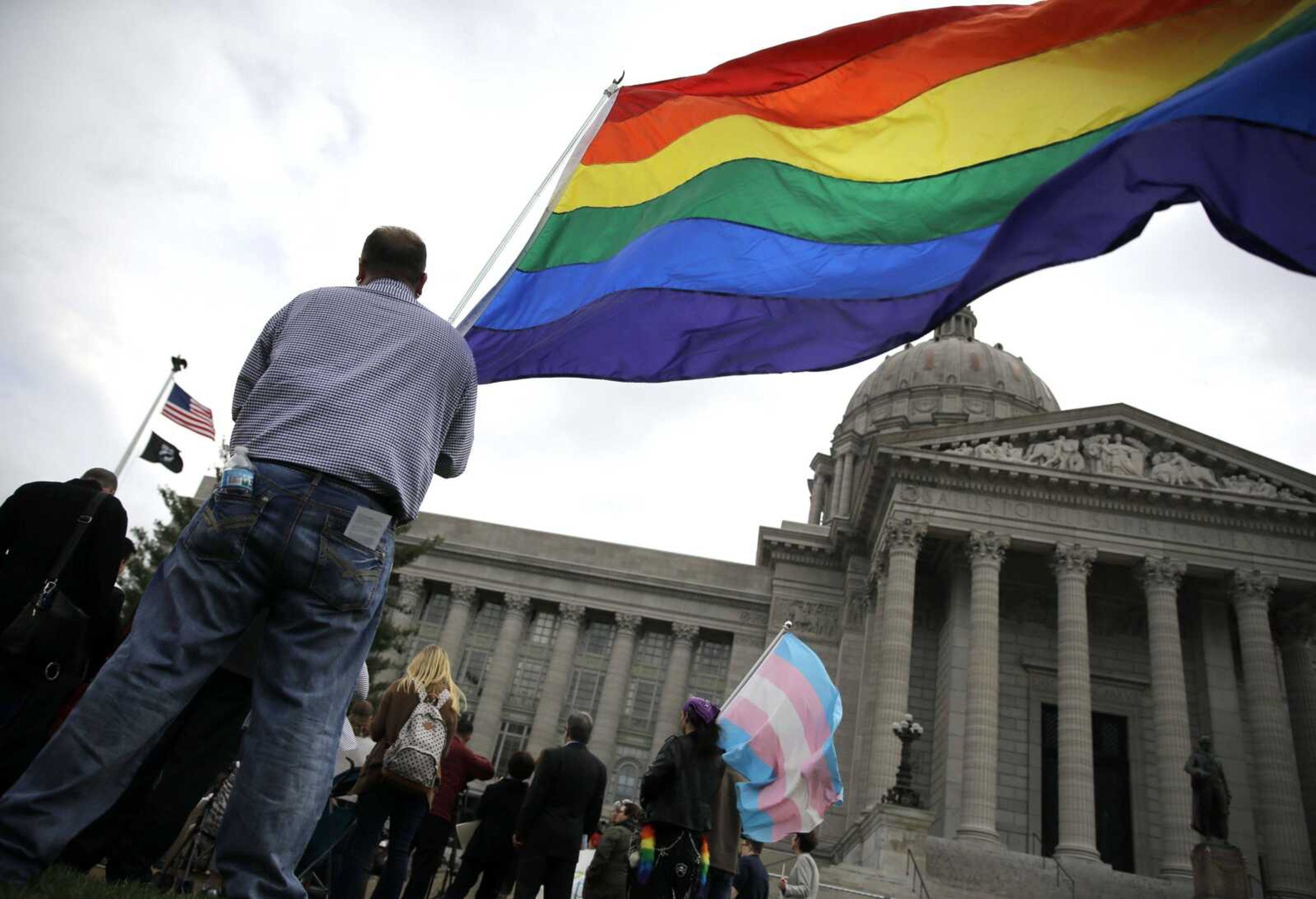 Gay-rights supporter Mathew "Skippy" Mauldin holds a flag during a gay rights rally March 31 outside the Capitol in Jefferson City, Mo. A Republican Missouri lawmaker says he has a solution to end tense debates over same-sex marriage. Rep. T.J. Berry wants to take government out of marriage and leave it to houses of worship by classifying such legal partnerships as domestic unions.