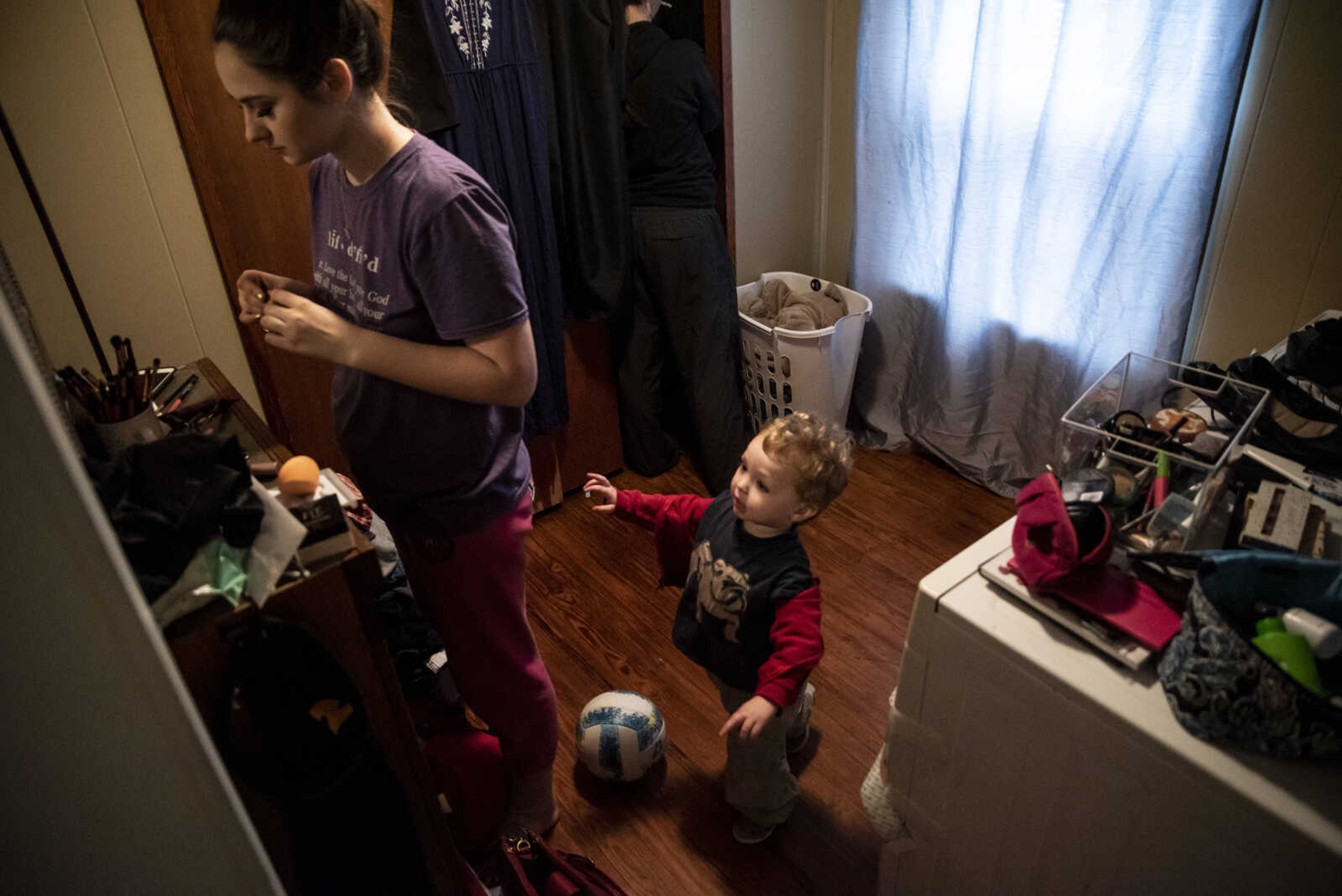 Emily Medlock gets ready for her graduation while her son, Phoenix Young, 2, drops a ball and wants attention at home Sunday, May 12, 2019, in Cape Girardeau.