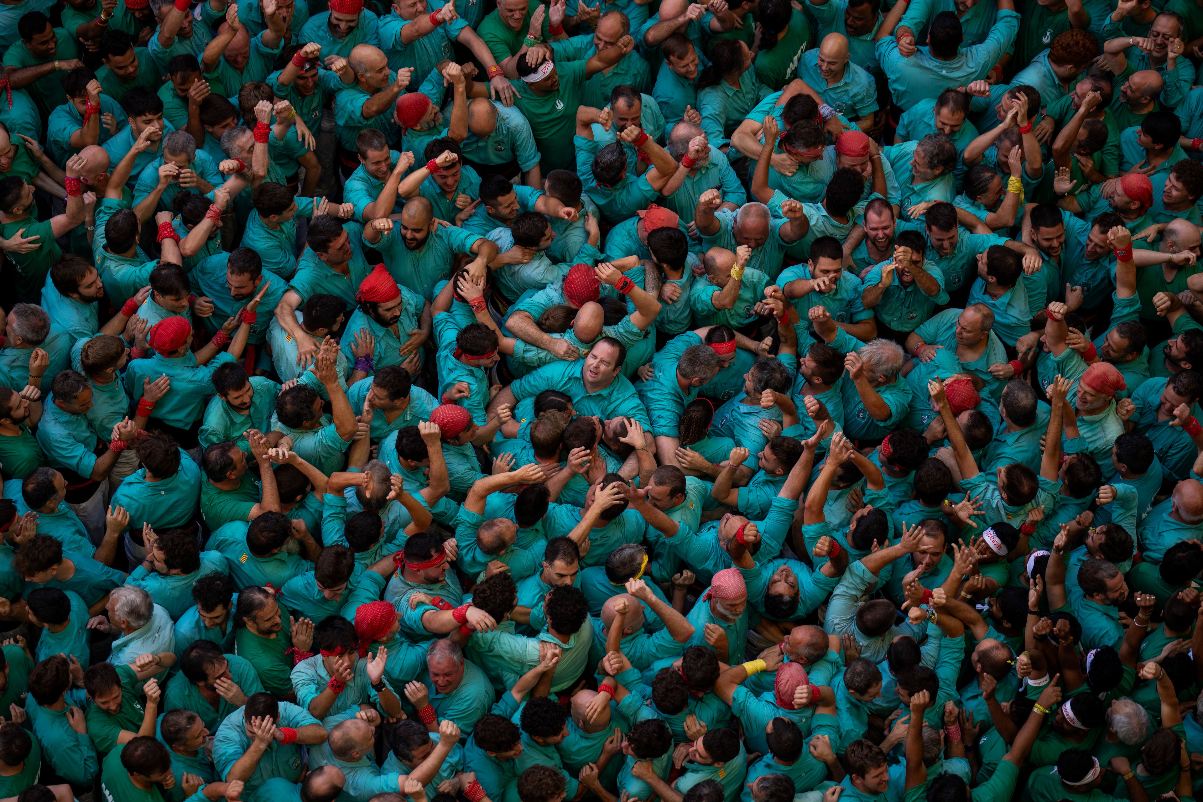 Members of "Castellers de Vilafranca" celebrate after completing a "Castell" or human tower, during the 29th Human Tower Competition in Tarragona, Spain, Sunday, Oct. 6, 2024. (AP Photo/Emilio Morenatti)