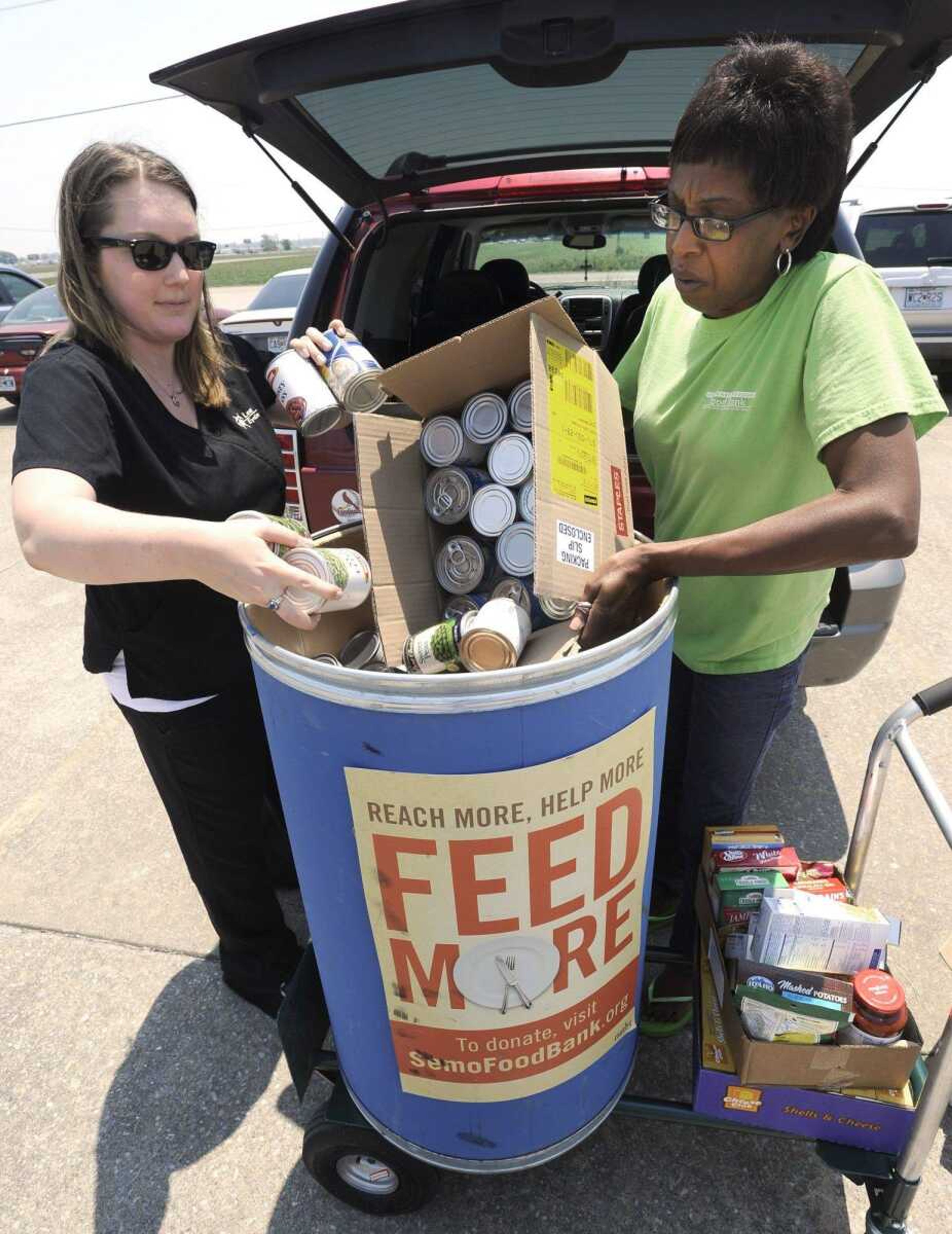 Jessica Espinoza, left, of Leet EyeCare, unloads food collected by employees Friday with Mary Thatch, community outreach coordinator with the Southeast Missouri Food Bank. (Fred Lynch)