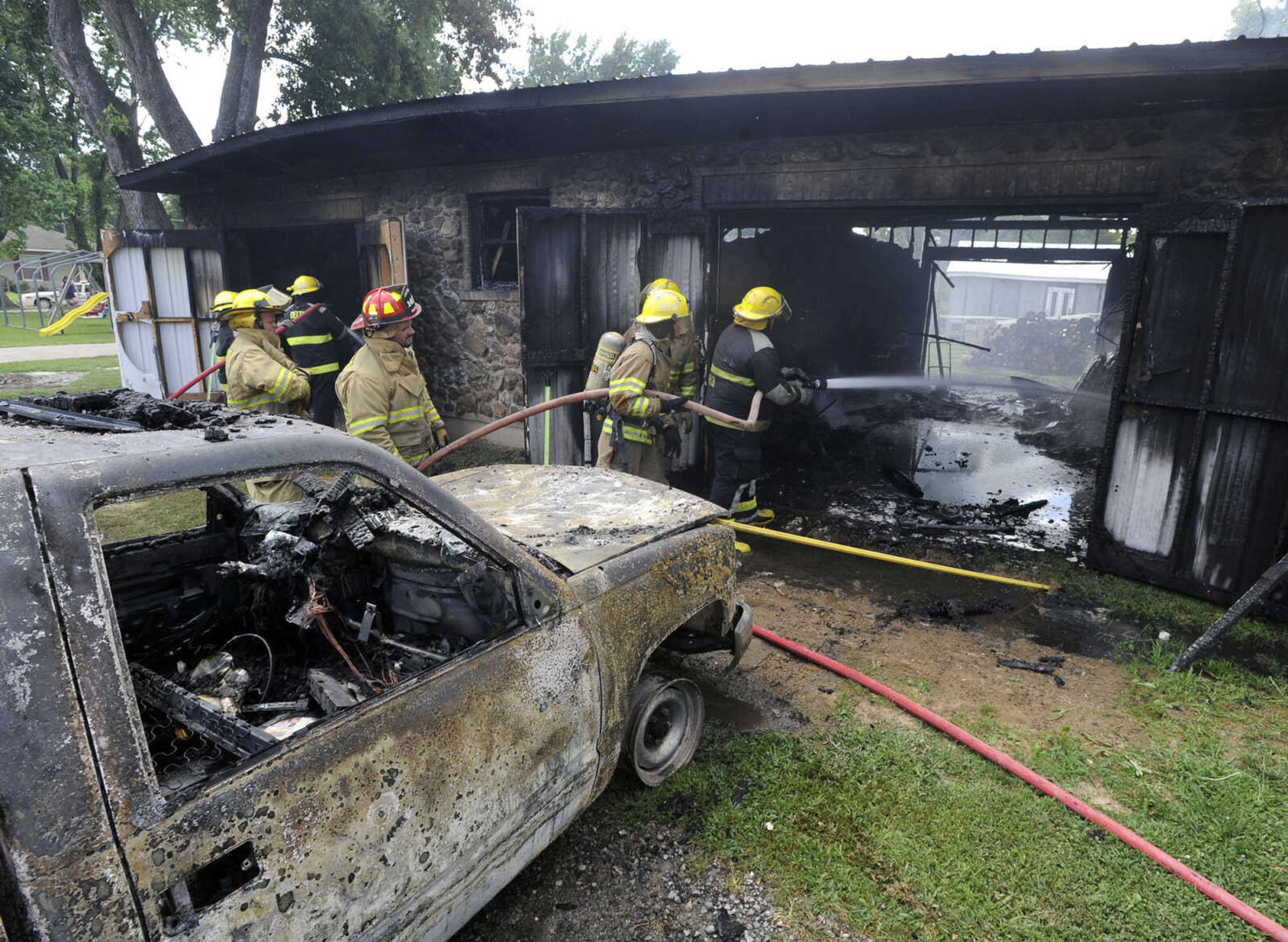 Firefighters from Chaffee, Oran and Delta fire departments work a fire that destroyed a wood-and-brick shed and a pickup truck inside on Monday, July 28, 2014 at 111 West Parker Ave. in Chaffee, Missouri. (Fred Lynch)