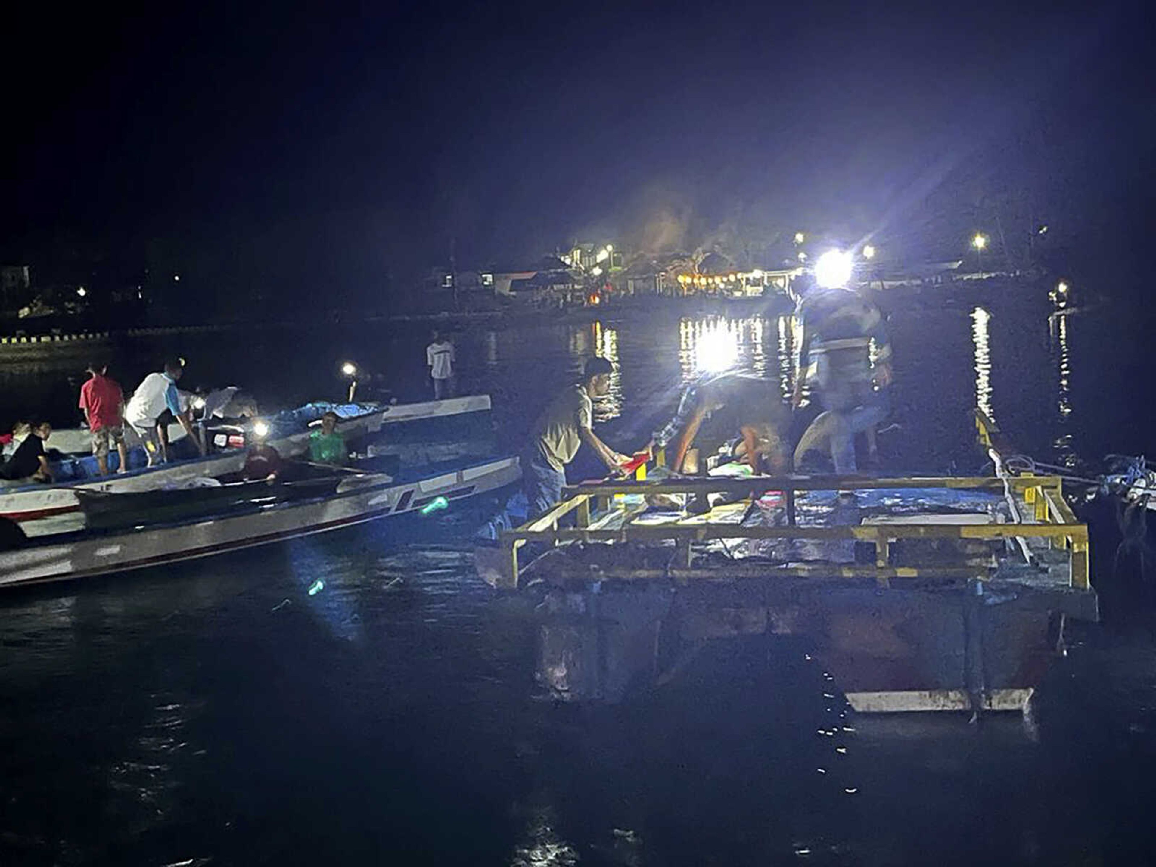 In this photo released by the National Search and Rescue Agency (BASARNAS), residents and members of the agency search for survivors after an overloaded ferry capsized off Indonesia's Sulawesi island, Monday, July 24, 2023. (BASARNAS via AP)