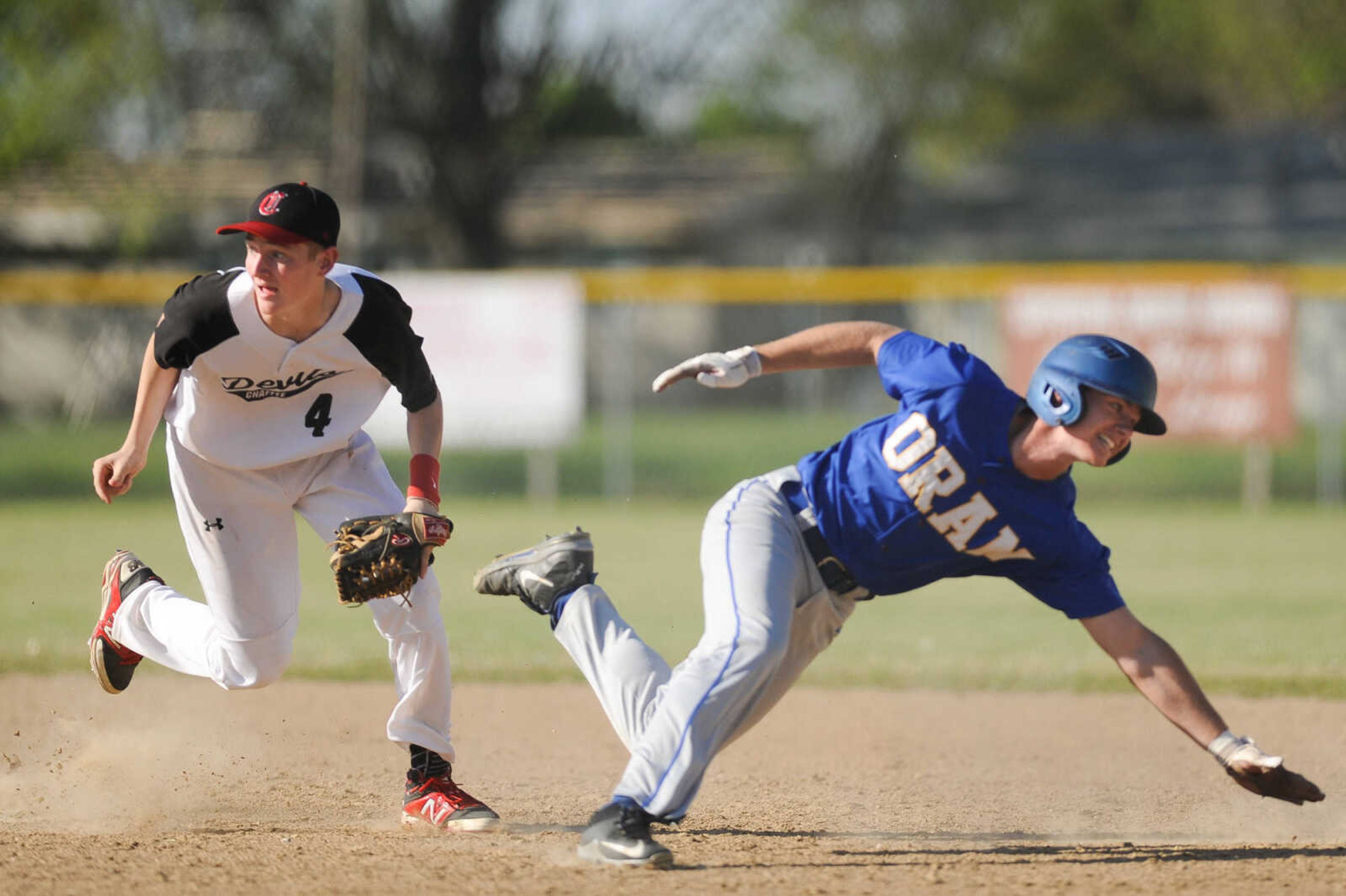 Oran's Tanner McVay makes a dive back to first base after Chaffee's Alec Bogenpohl chased him during a play in the third inning Friday, April 15, 2016 in Chaffee Missouri.