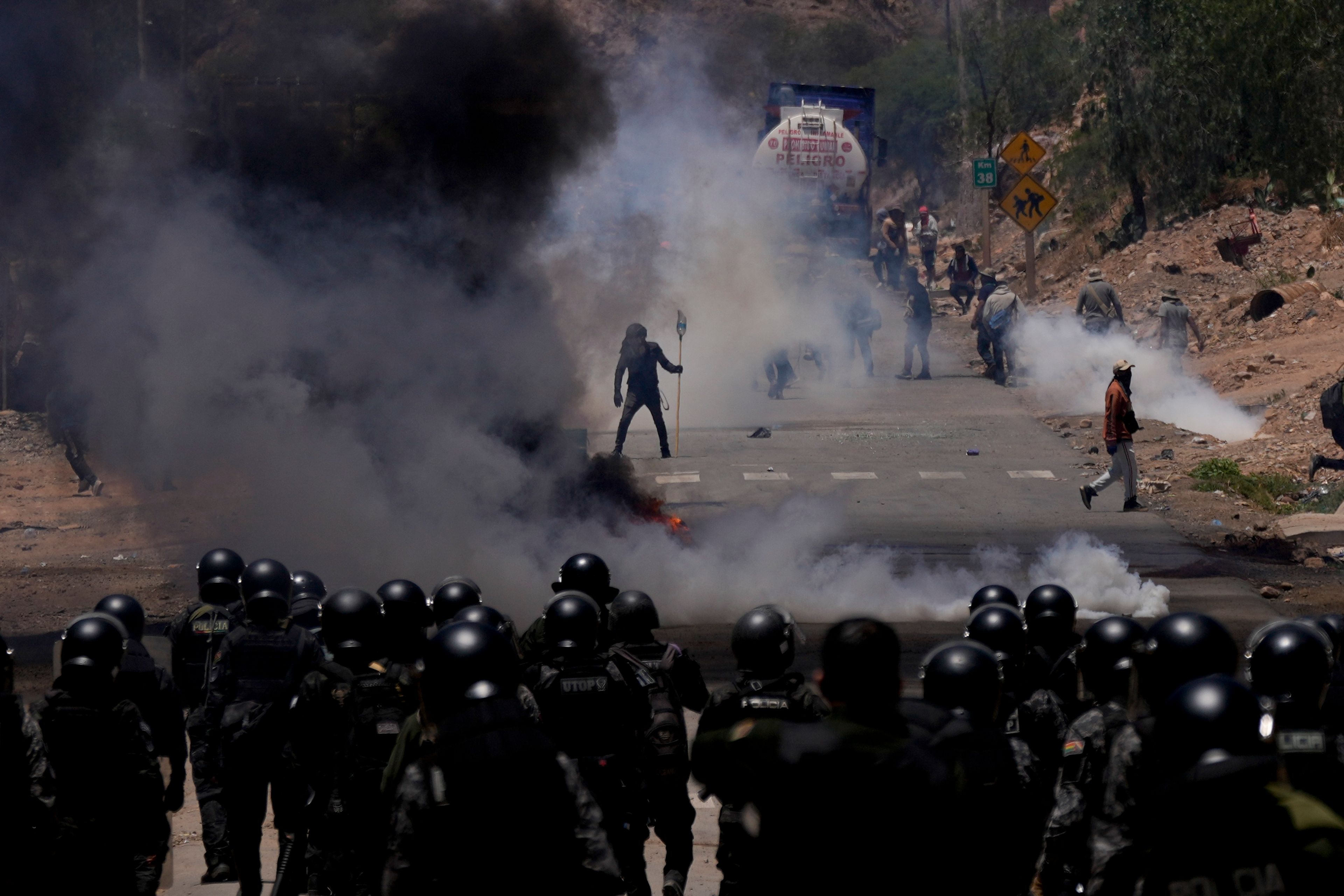 FILE - Police launch tear gas to disperse backers of former President Evo Morales who have been blocking roads for weeks partly targeting President Luis Arce's handling of the economy, in Parotani, Bolivia, Nov. 1, 2024. (AP Photo/Juan Karita, File)