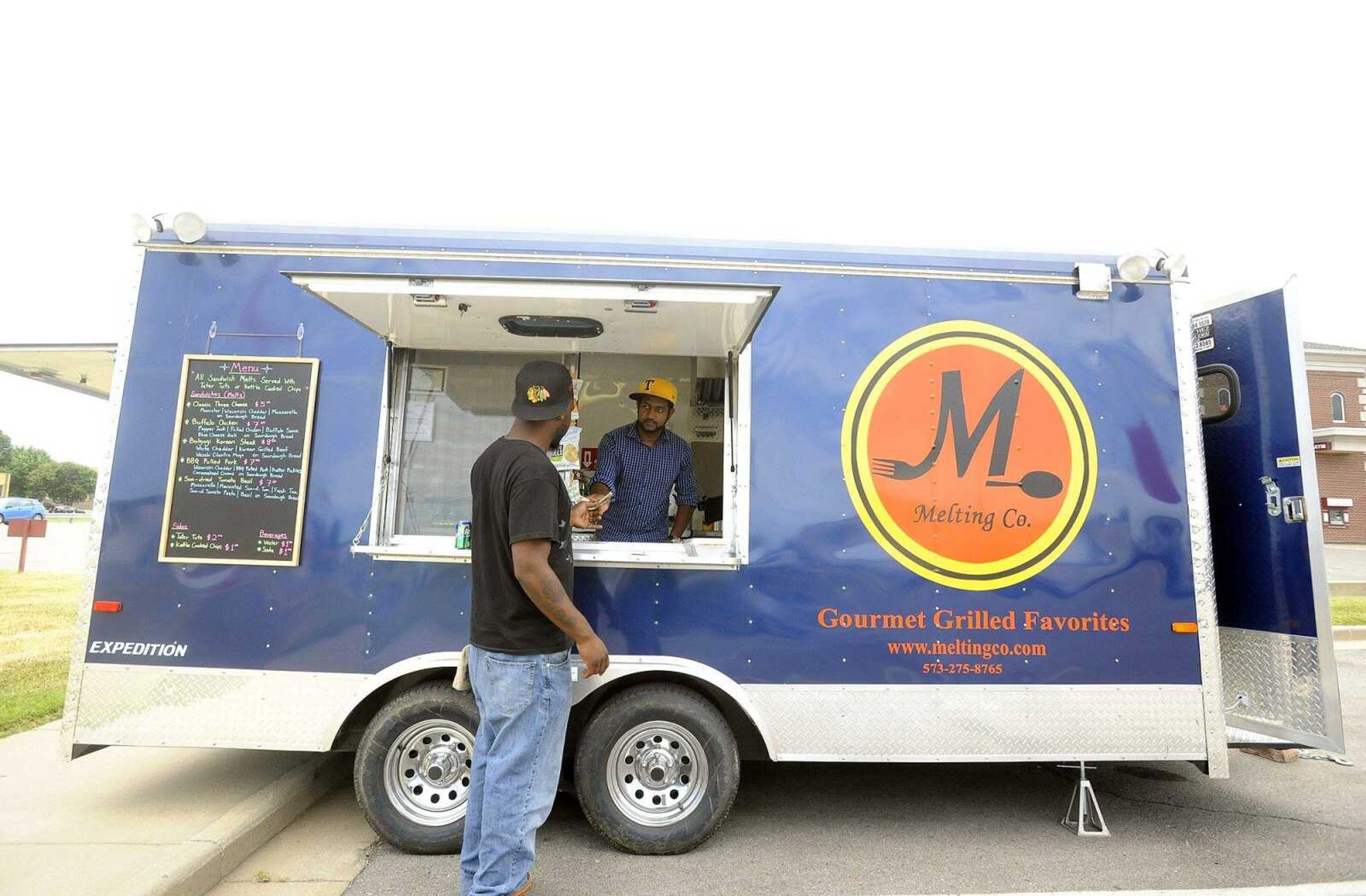 Kavimal Senadeera helps a customer at the Melting Co. food truck while it was parked at Plato's Closet in Cape GIrardeau on Friday afternoon.