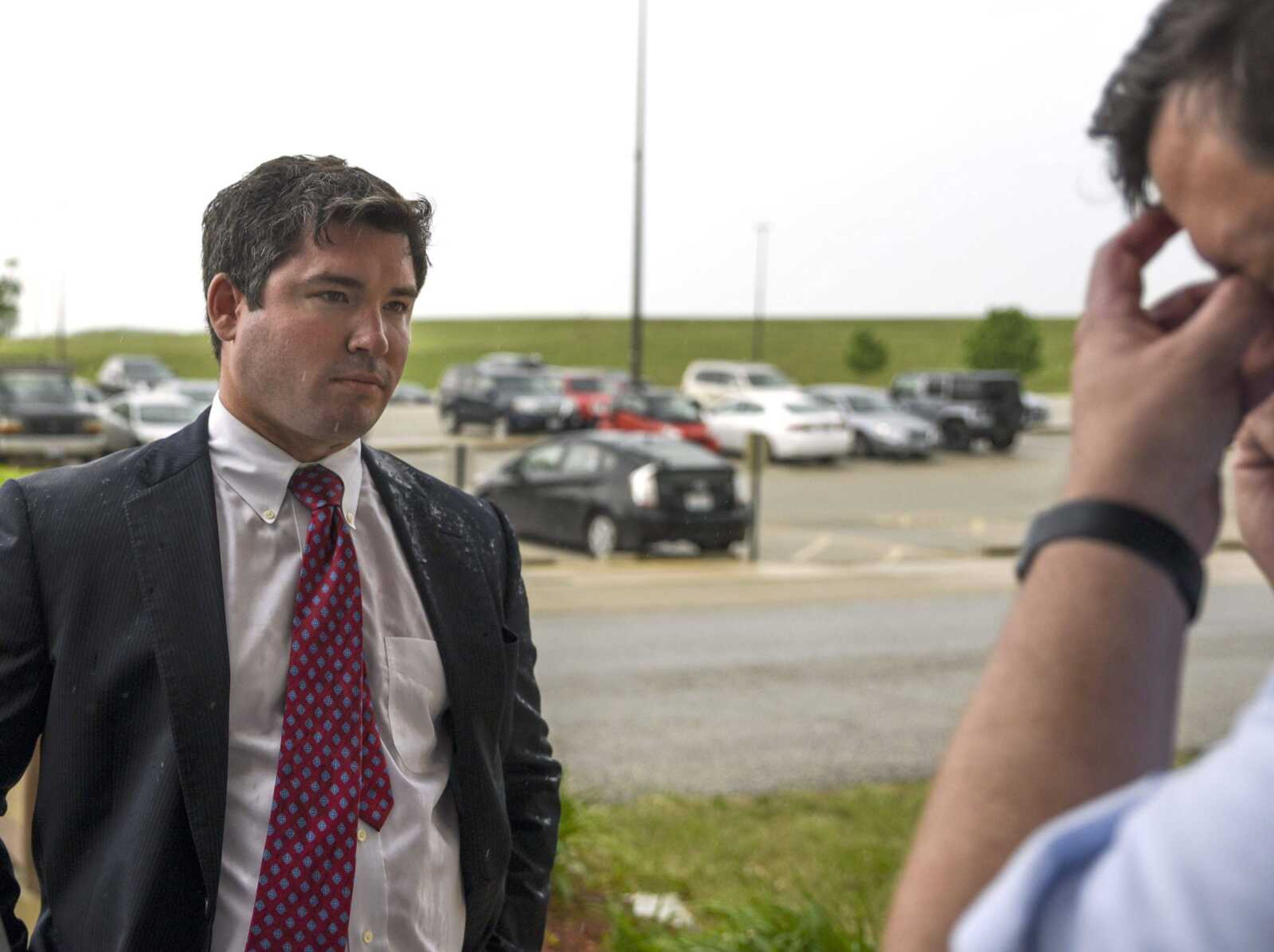 Jonathan Potts listens as Jim Wyrsch talks on the phone in front of the Jefferson City Correctional Center on Monday in Jefferson City, Missouri.