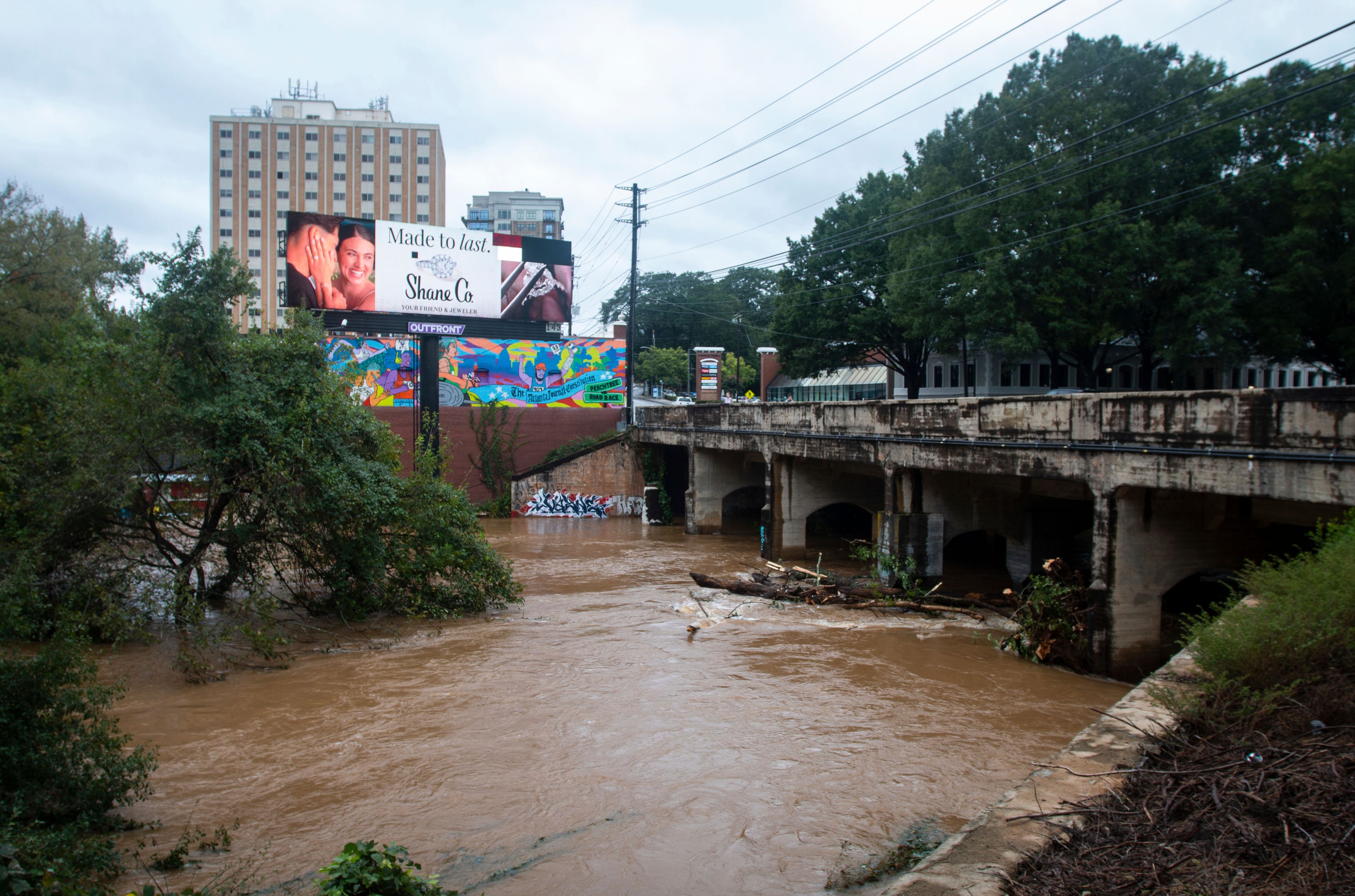 An overpass above a swollen and rushing Peachtree Creek, the site of a major Civil War battle, is seen overflowing its lower banks after Hurricane Helene passed the area on Friday, Sept. 27, 2024, in Atlanta. (AP Photo/Ron Harris)