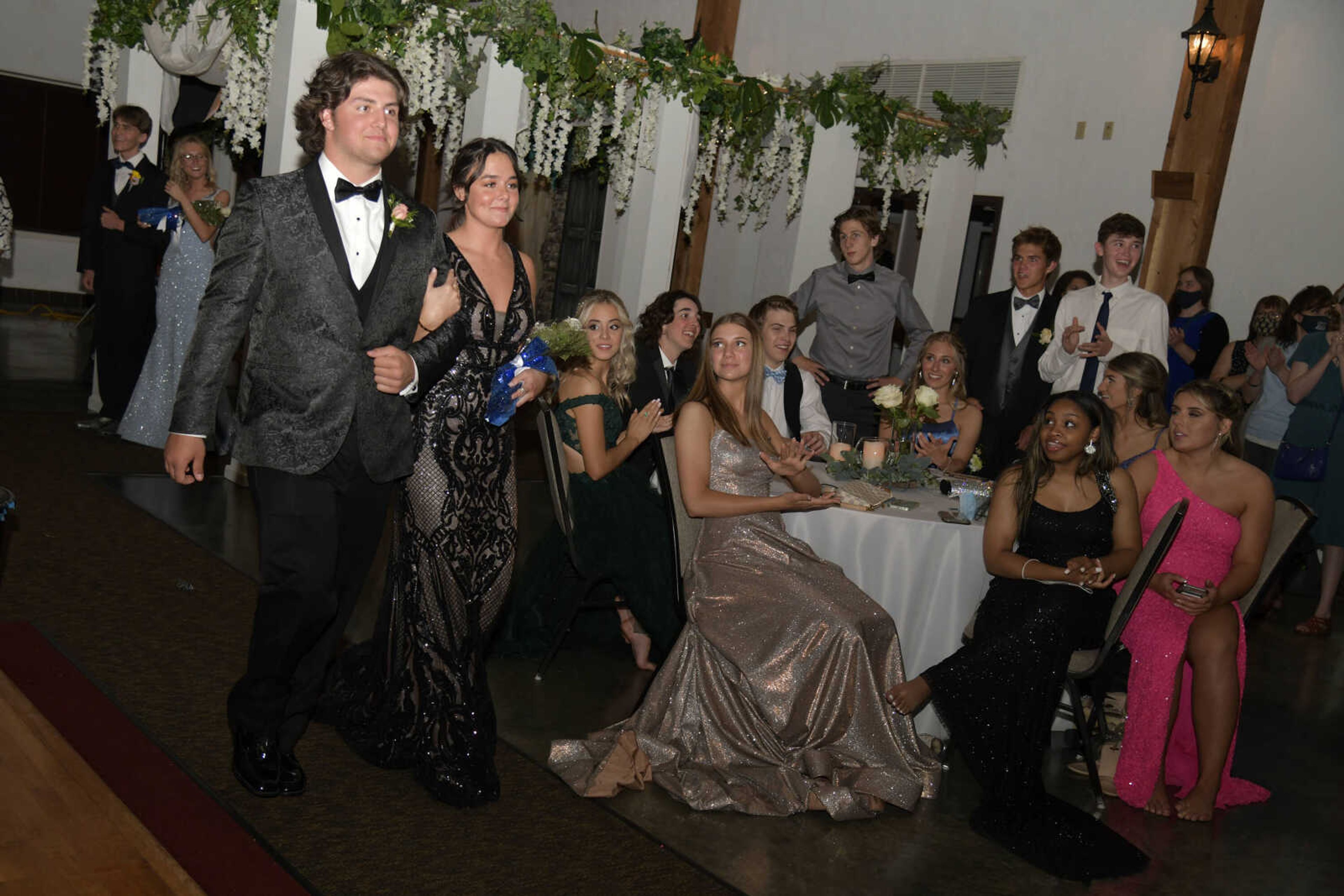 Prom candidates Austin Gast and Delaney Shaffer walk to the dance floor while being announced during Notre Dame's prom at Bavarian Halle in Jackson on Friday, April 30, 2021.