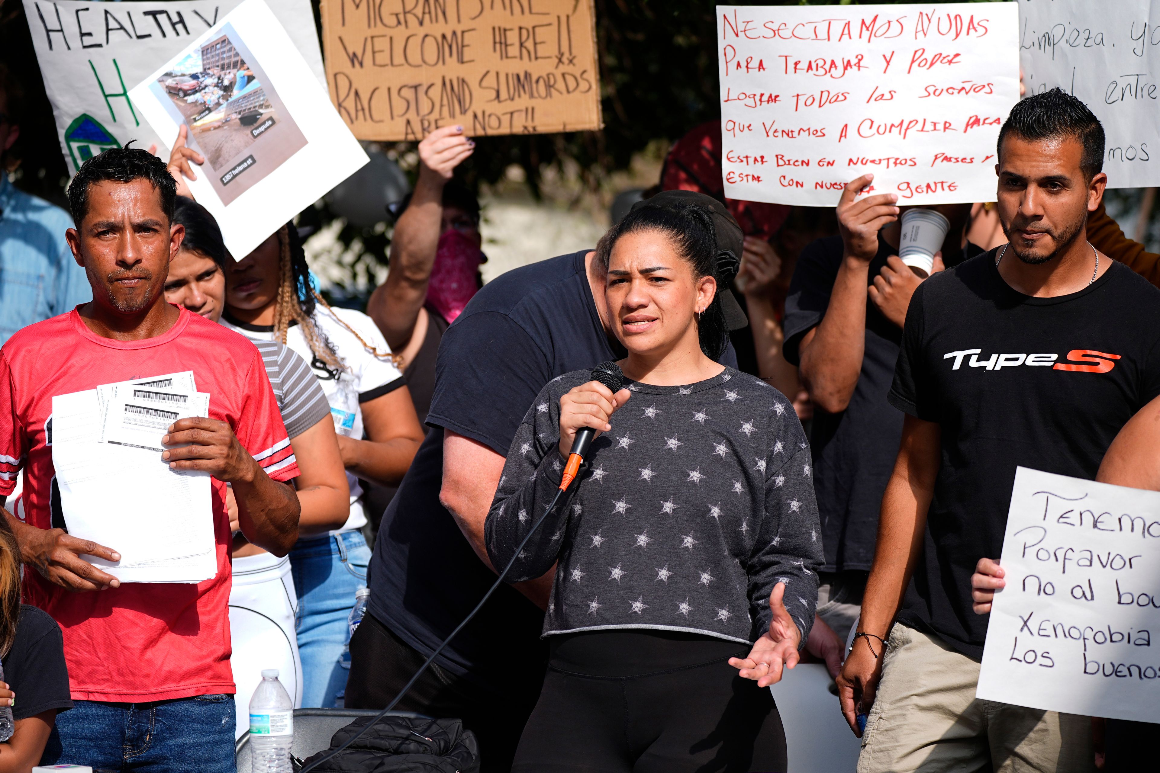 FILE - Juan Carlos Jimenez, left, listens as Geraldine Massa speaks during a rally staged by the East Colfax Community Collective to address chronic problems in the apartment buildings occupied by people displaced from their home countries in central and South America, Sept. 3, 2024, in Aurora, Colo. (AP Photo/David Zalubowski, File)